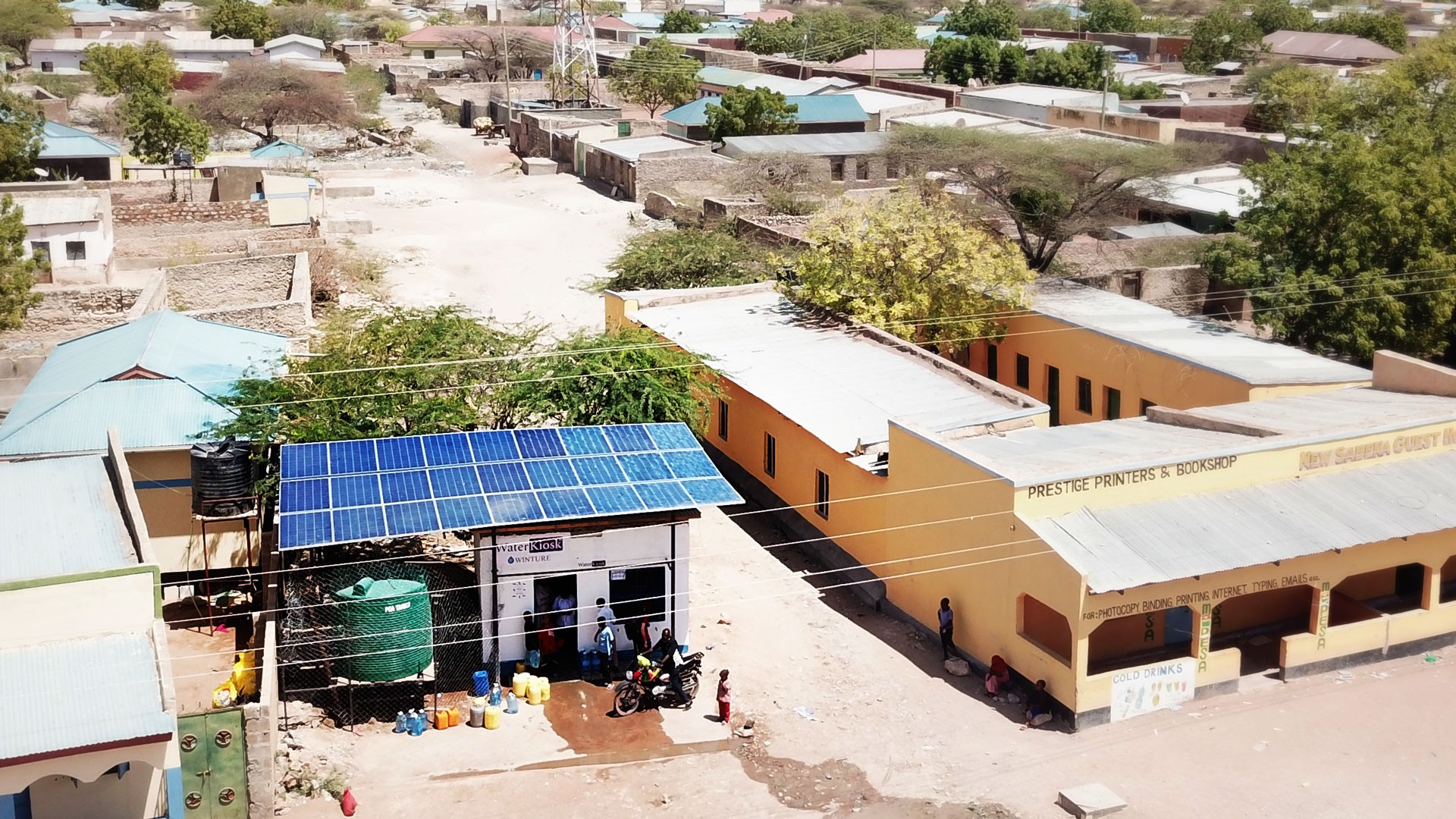 A WatzerKiosk photographed from above with a view of the solar roof and water tank in the middle of a village of stone houses.