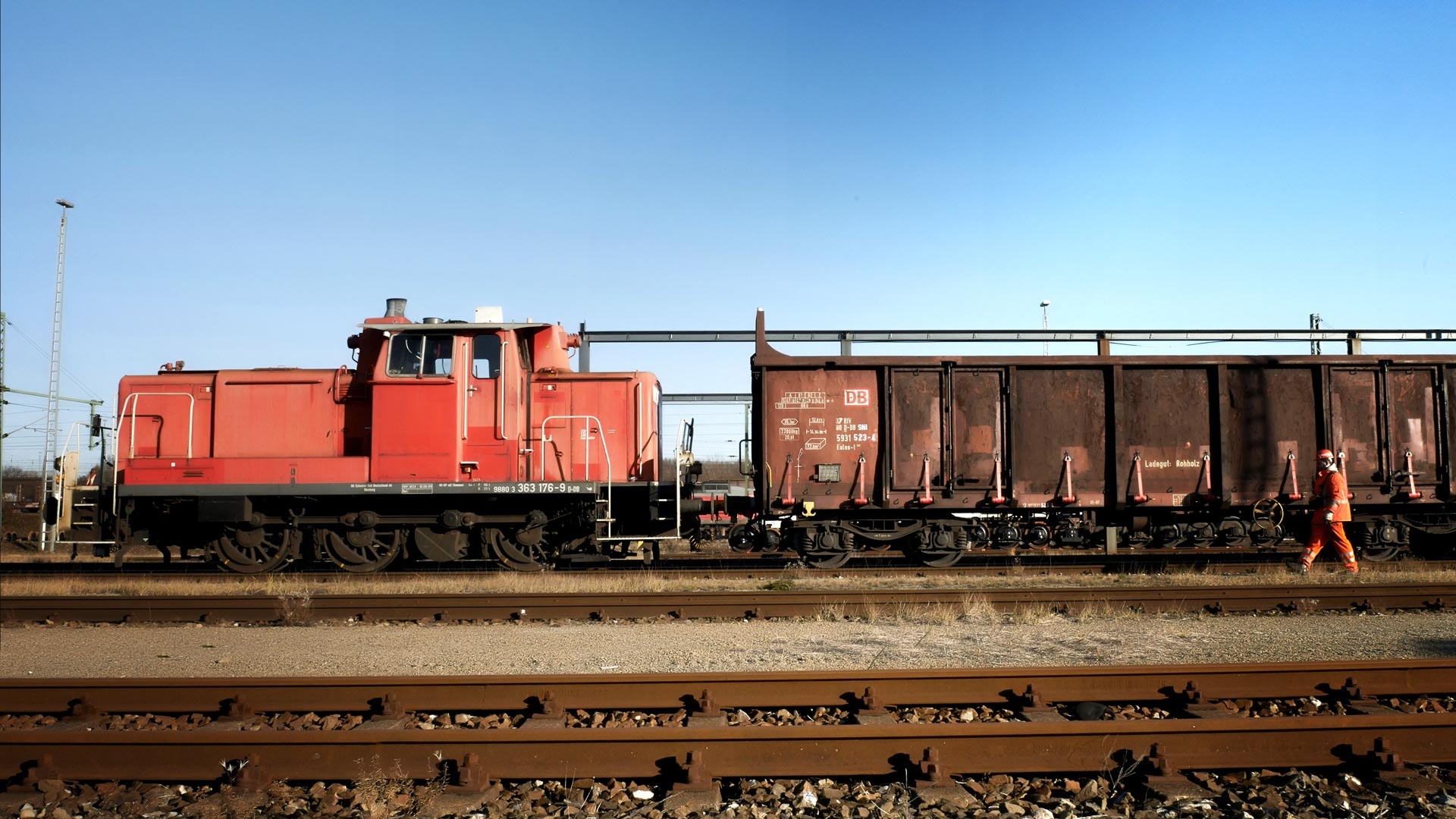 Freight-train-locomotive-with-a-car-and-a-shunting-worker-infront-of-the-train