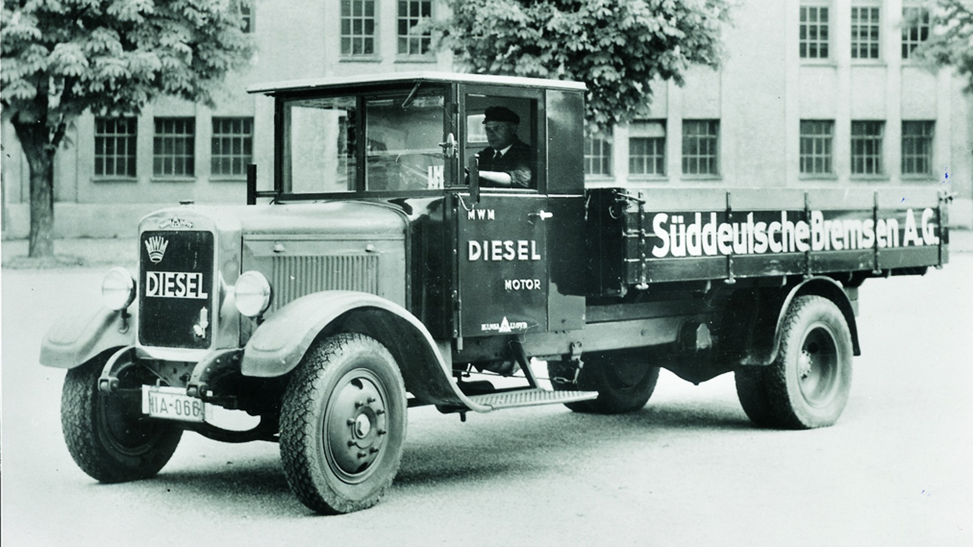 Black and white photo of a historical truck with the inscription "Süddeutsche Bremse A.G." on the loading area