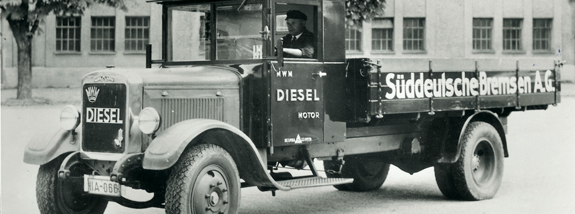 Schwarz-weiß-Foto eines historischen Lkw mit der Aufschrift "Süddeutsche Bremse A.G." an der Ladefläche