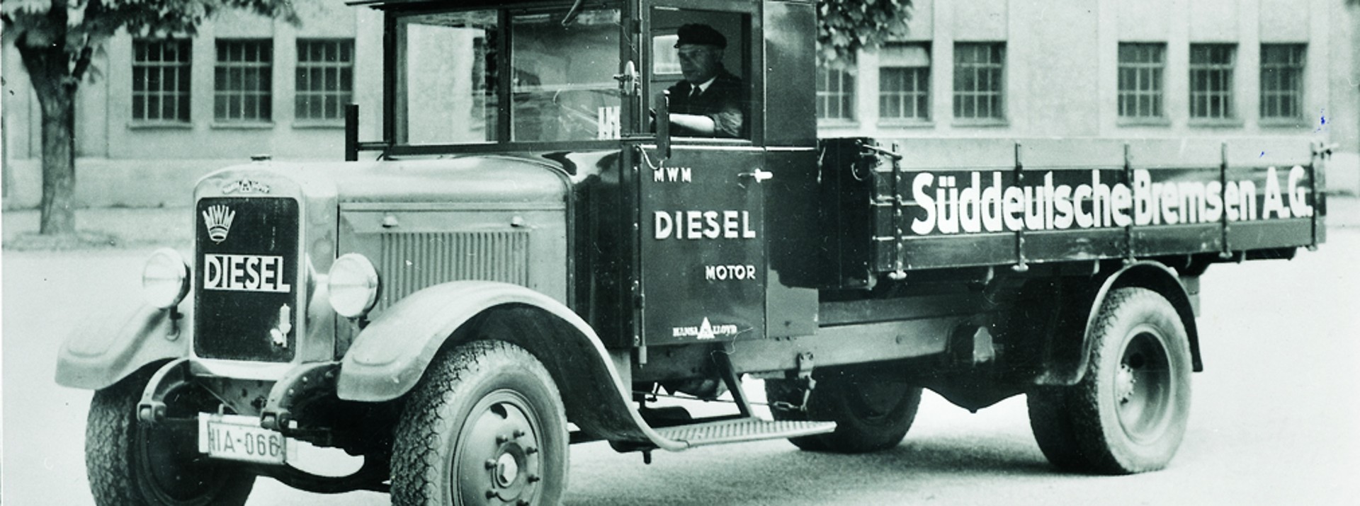 Schwarz-weiß-Foto eines historischen Lkw mit der Aufschrift "Süddeutsche Bremse A.G." an der Ladefläche