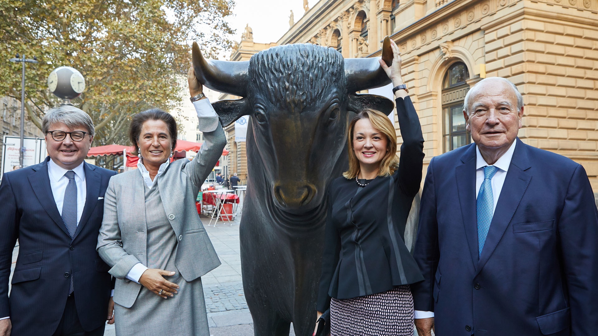 Deutsche Börse CEO Theodor Weimer and his wife Silke Weimer together with Heinz Hermann Thiele and his wife Nadia Thiele stand next to the legendary bull in front of Frankfurt Stock Exchange.
