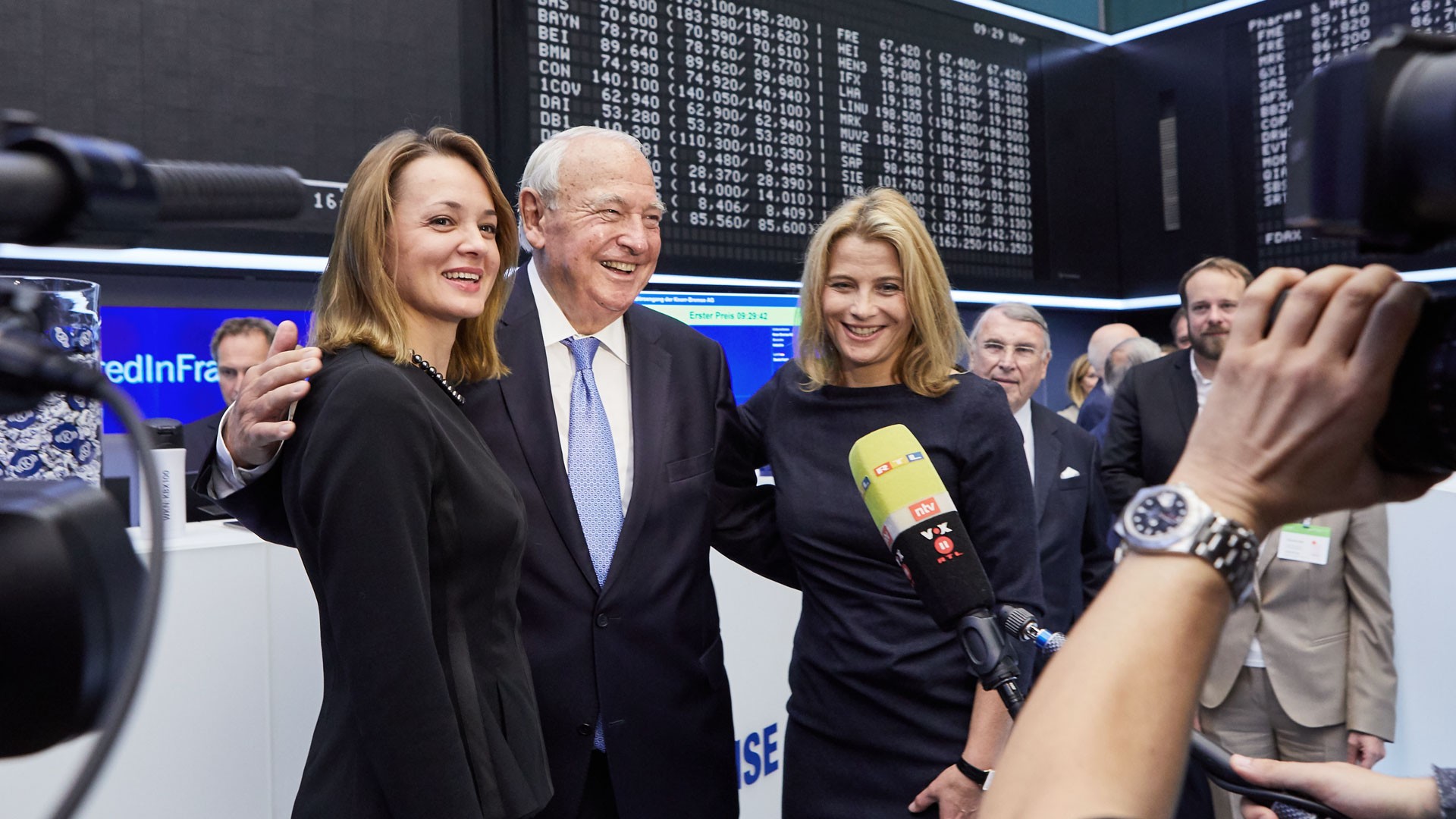 Heinz Hermann Thiele steht auf dem Frankfurter Börsenparkett zwischen seiner Ehefrau Nadia Thiele und seiner Tochter Julia Thiele-Schürhoff vor Fernsehkameras; alle drei lachen und strahlen nach dem erfolgreichen Börsenstart der Knorr-Bremse Aktie.