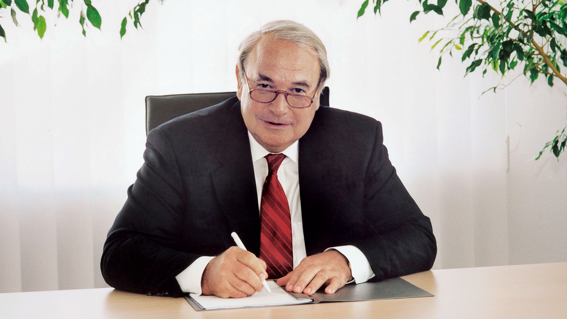 1985: Heinz Hermann Thiele sits at his desk and signs documents.