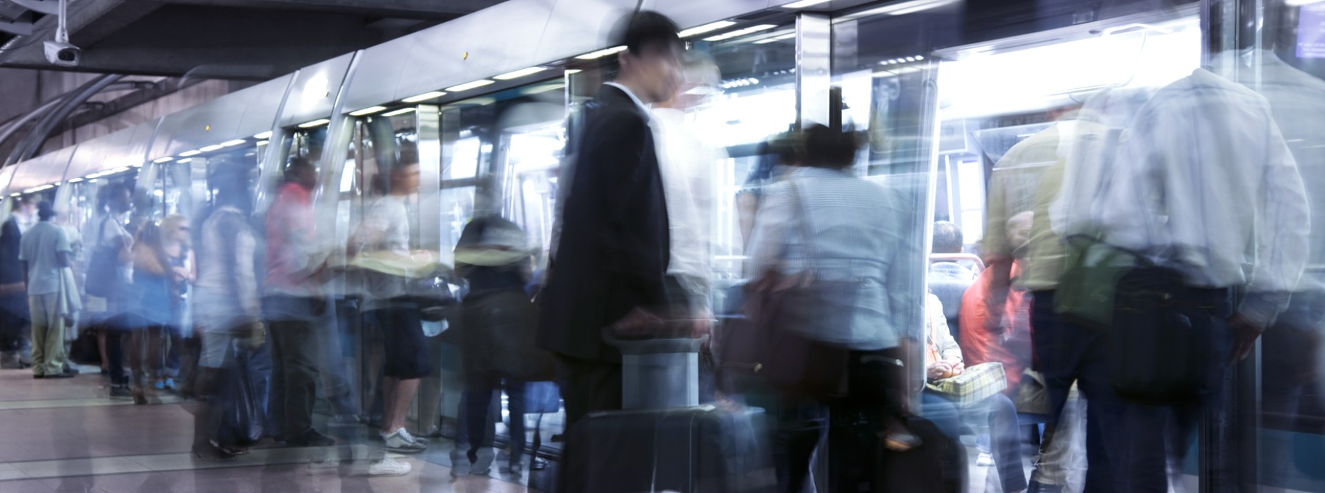 Many people get on and off the subway platform.