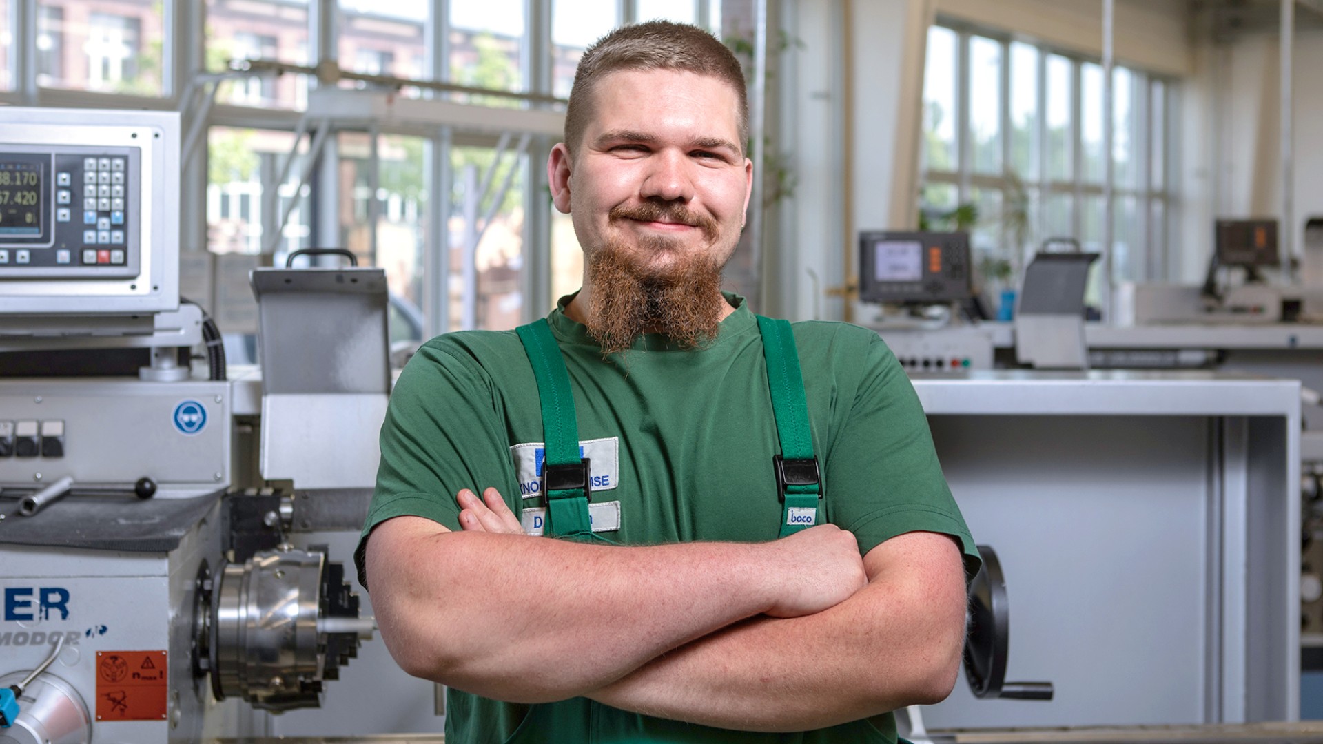 Dominik Bobon, Auszubildender zum Zerspanungsmechaniker in Berlin, vor einer Maschine in der Lehrwerkstatt.