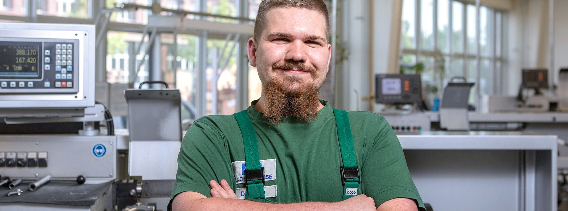 Dominik Bobon, Auszubildender zum Zerspanungsmechaniker in Berlin, vor einer Maschine in der Lehrwerkstatt.