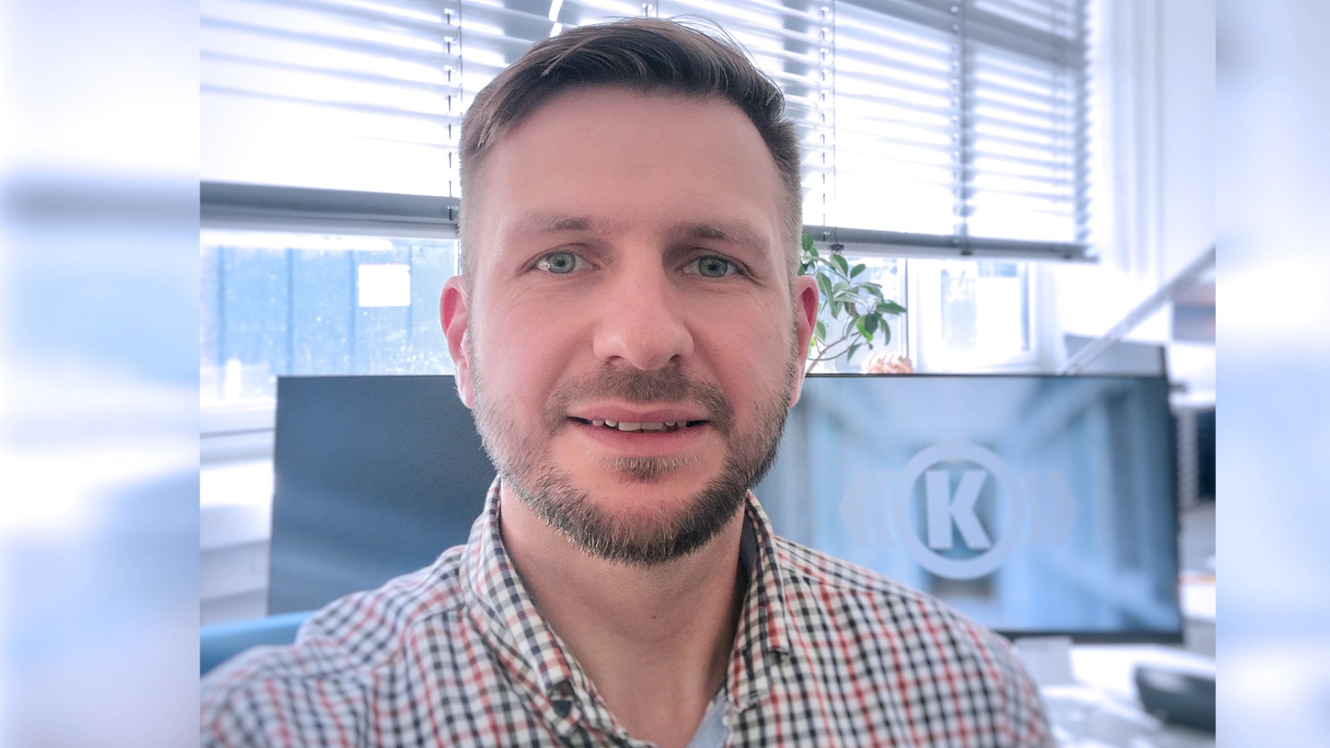 Portrait of Manuel Zimmermann, Head of Training at Knorr-Bremse’s Berlin site, in his office in front of his PC screen.