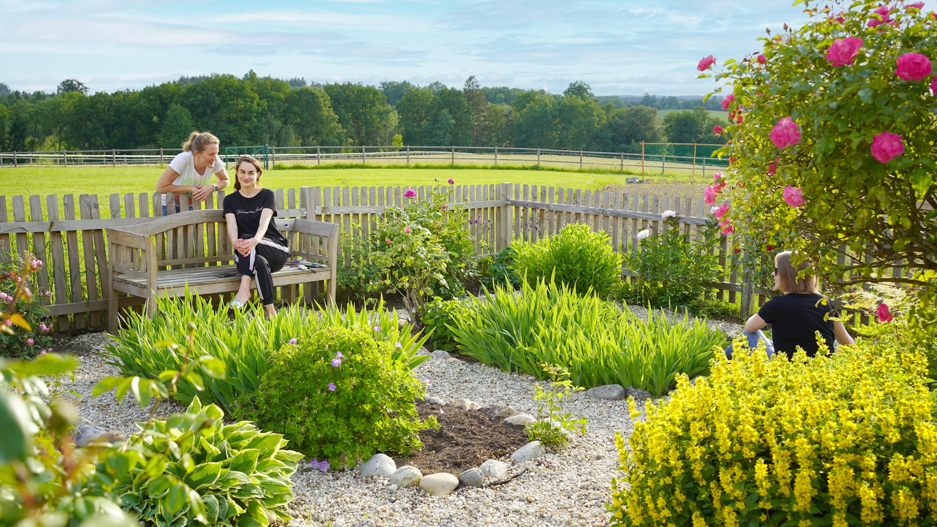 Three Ukrainian mothers enjoy a few quiet minutes in the farm's flower garden.