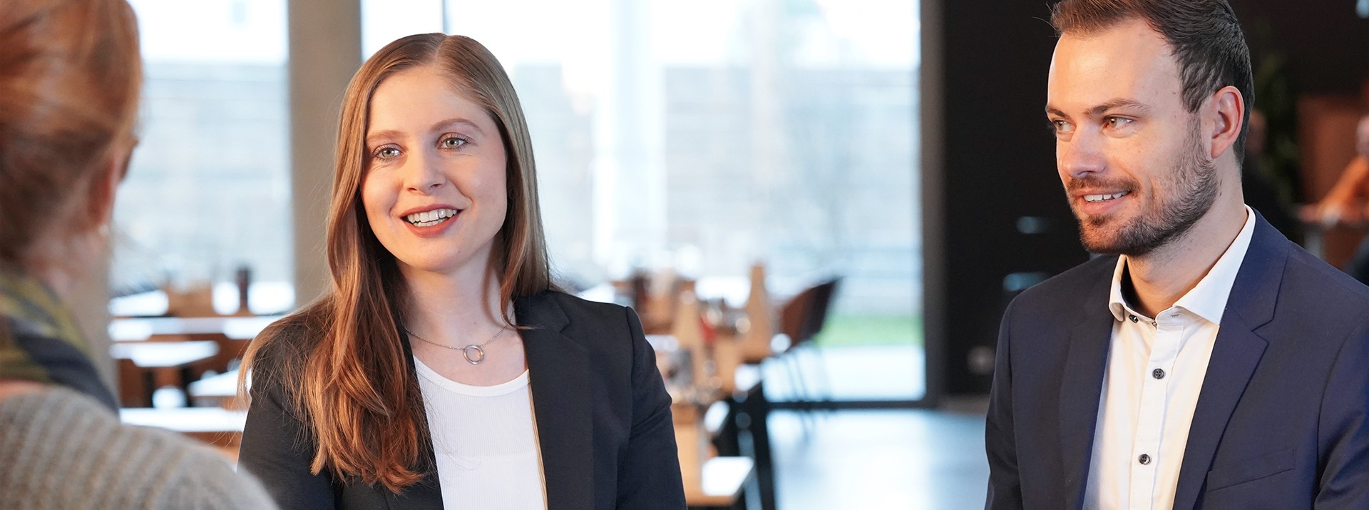 Two trainees, Elina Steinke and Johannes Weth, talk about their experiences with the MEP trainee program at a table in the cafeteria at the Knorr-Bremse site in Munich.