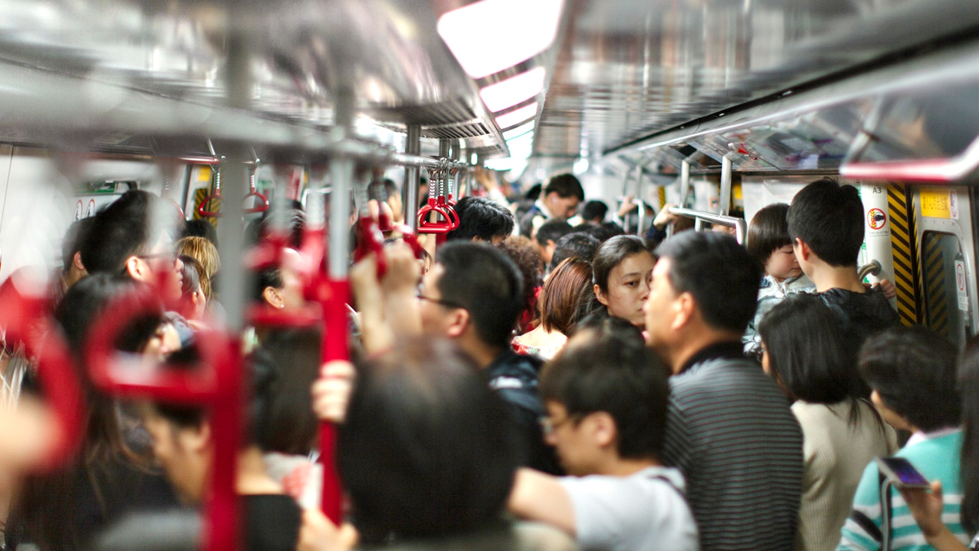 Innenansicht einer mit Menschen überfüllten U-Bahn in Hong Kong, China.