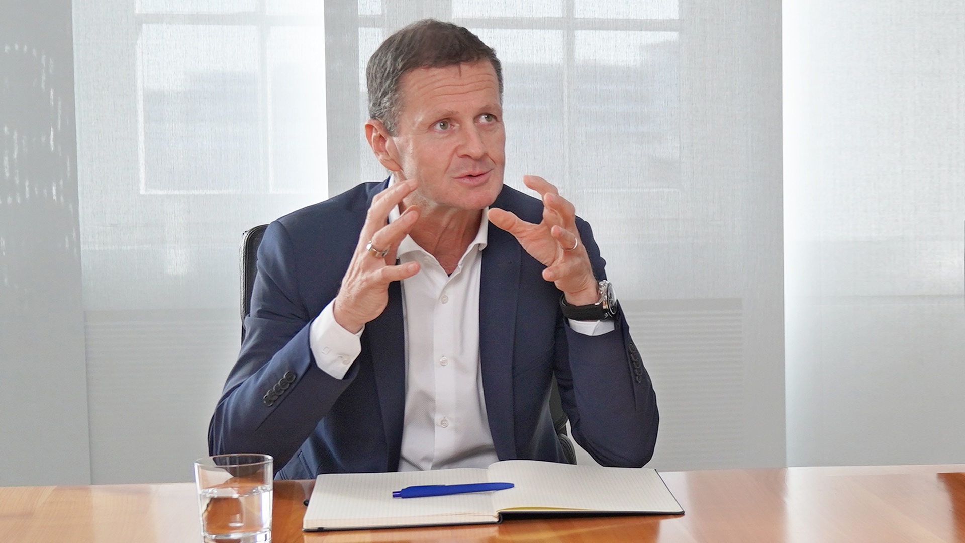 Frank Markus Weber, Finanzvorstand der Knorr-Bremse AG, sitzt gestikulierend an einem Besprechungstisch und gibt ein Interview.