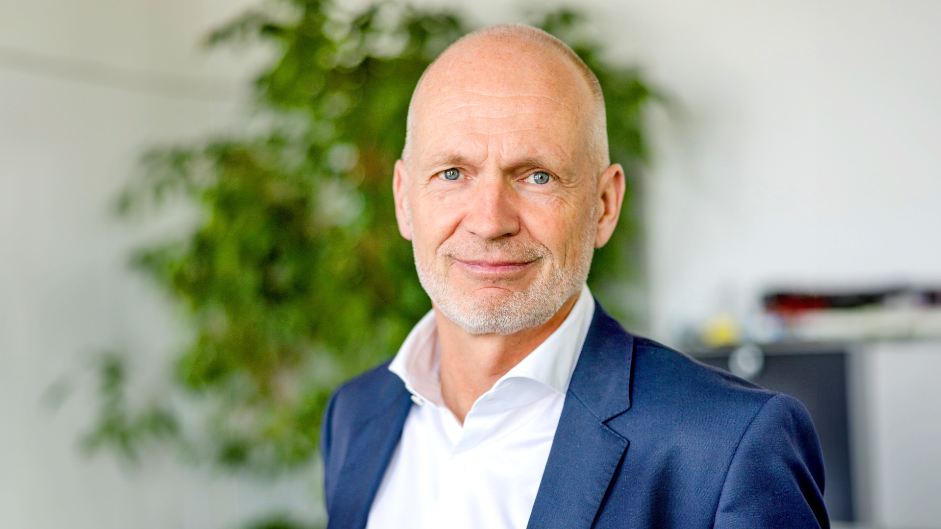 Portrait of Dr Nicolas Lange, Member of the Executive Board of Knorr-Bremse AG and responsible for the Rail Vehicle Systems division; taken in his office, with a houseplant in the background.