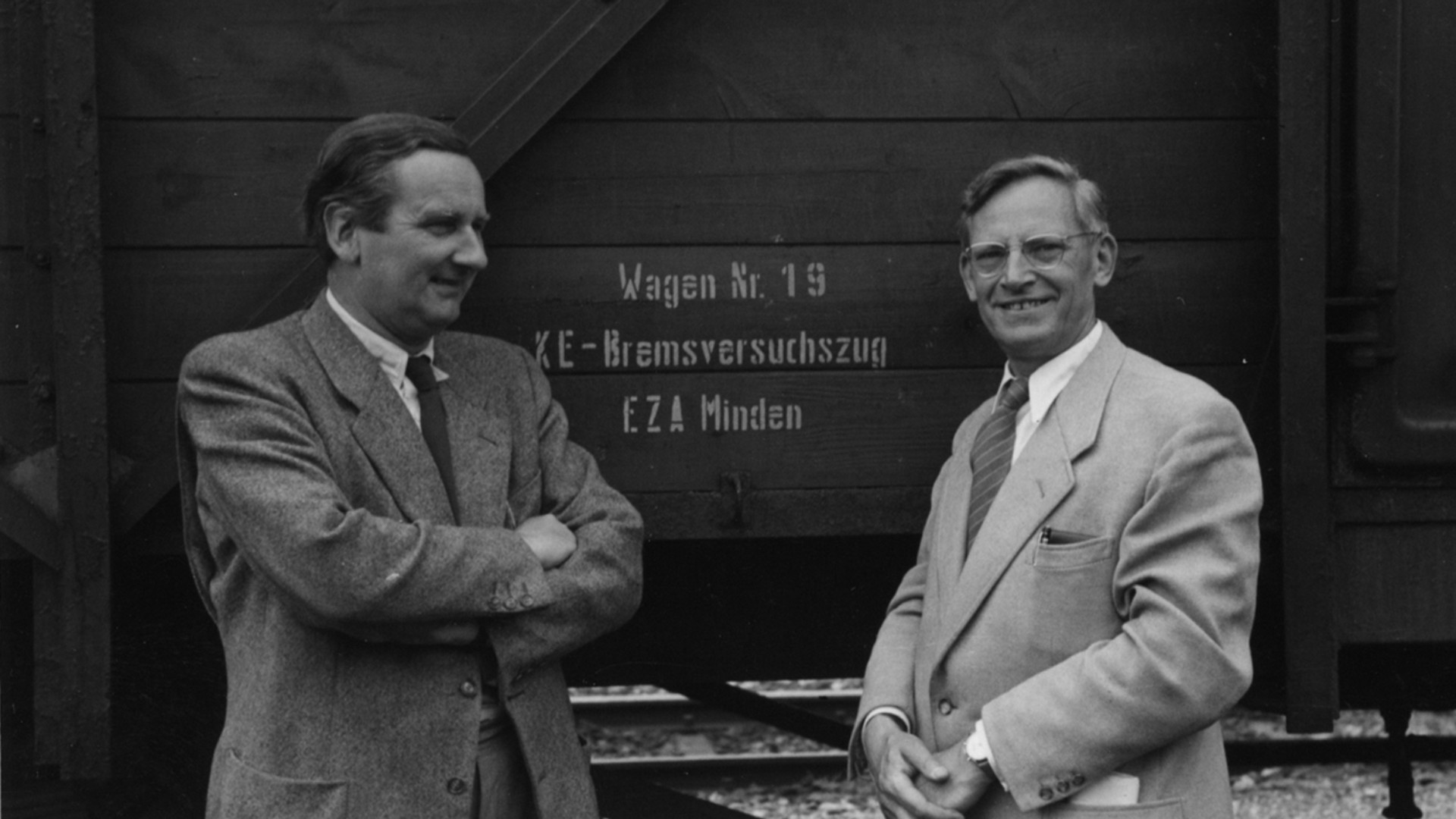 Zwei Männer vor einem historischen Güterwaggon mit der Aufschrift ‚KE‑Bremsversuchszug‘