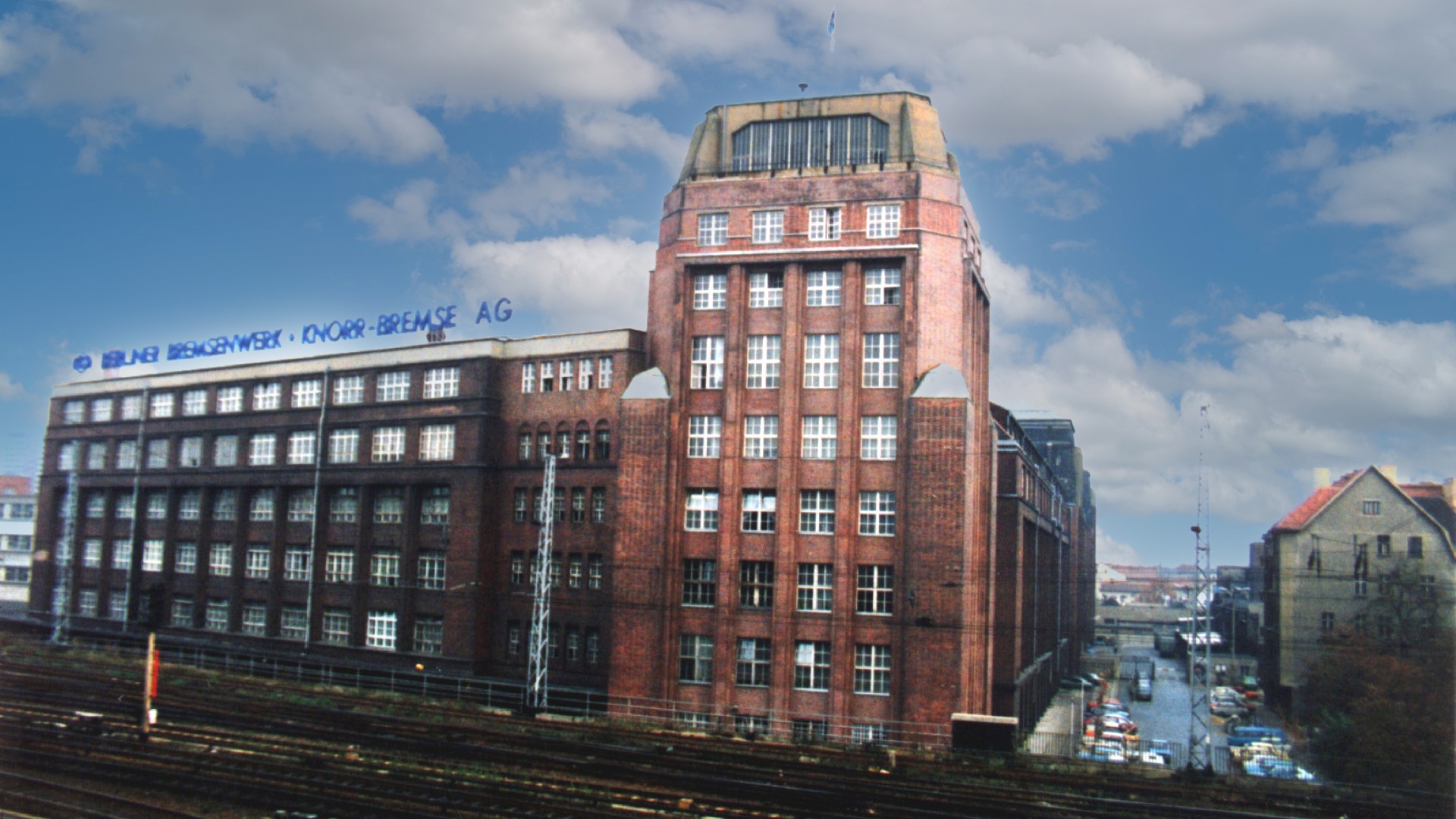 Historisches Bremsenwerk in Berlin, Backstein‑Industriegebäude an den Gleisanlagen mit der Firmenaufschrift VEB Berliner Bremsenwerk Knorr‑Bremse AG auf dem Dach