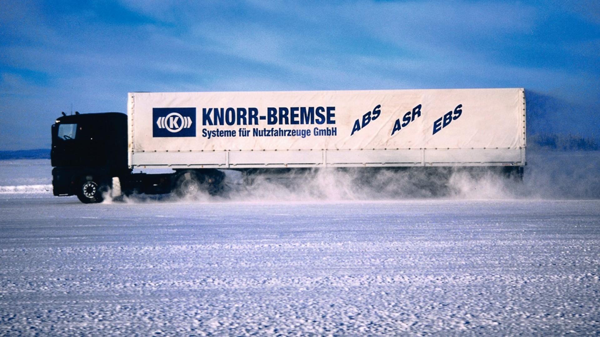 Lkw mit Knorr‑Bremse Branding bei einer Wintertestfahrt auf schneebedeckter Fahrbahn