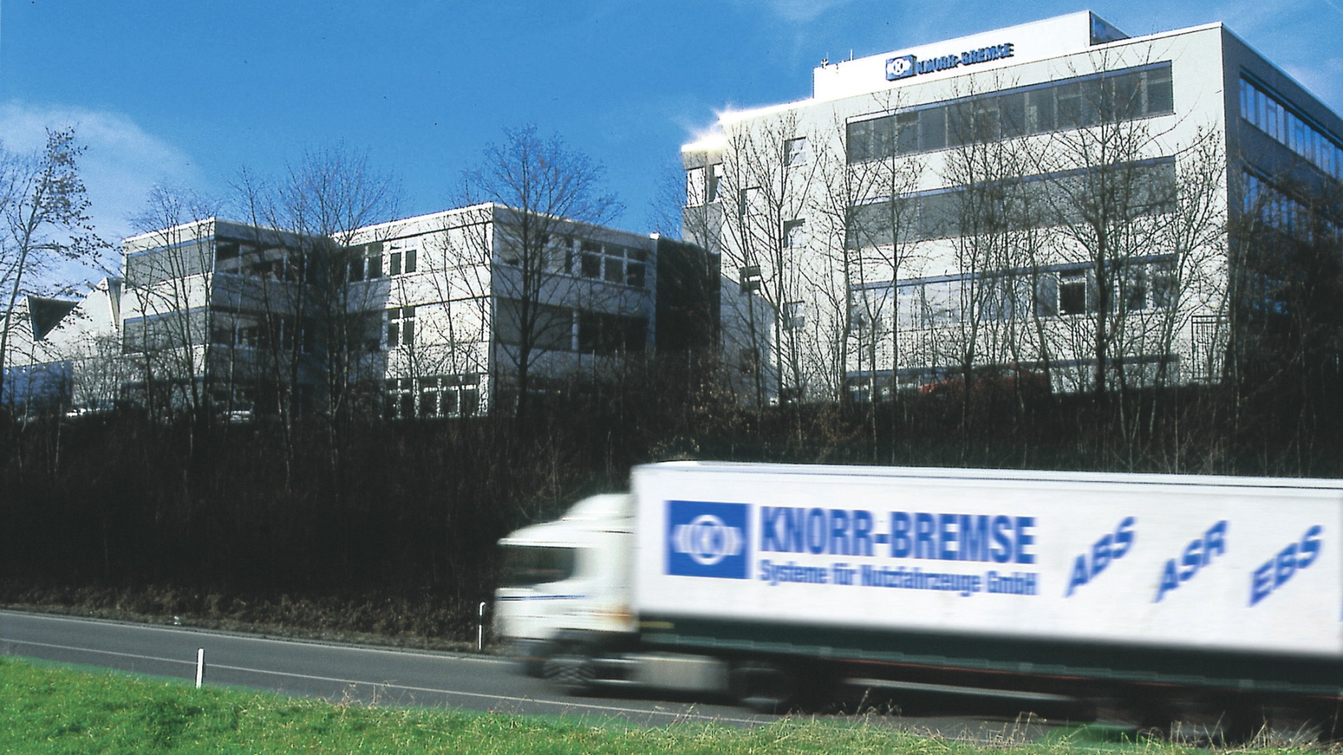 Lkw mit Knorr‑Bremse‑Branding auf einer Landstraße vor dem Standort Schwieberdingen