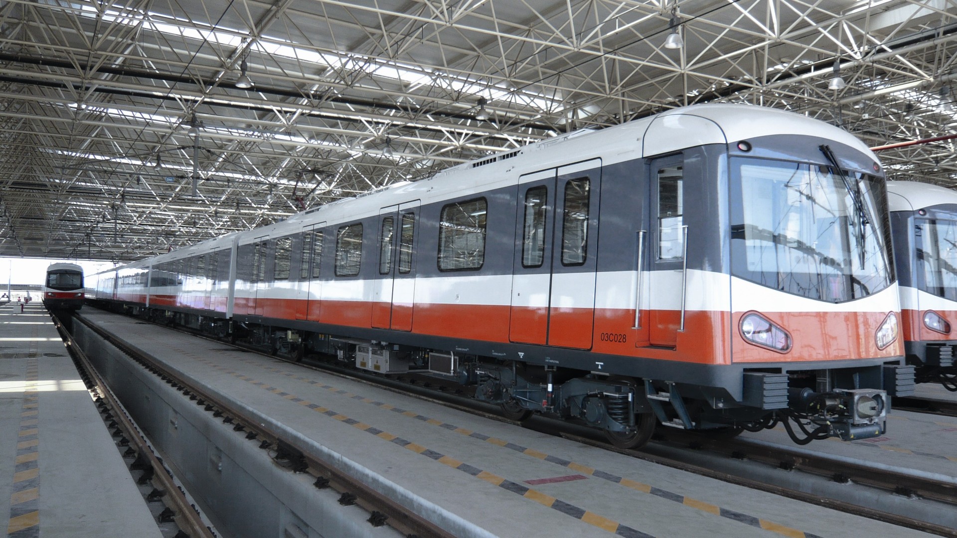 Mehrere Metrozüge in einer Wartungshalle auf erhöhten Gleisen