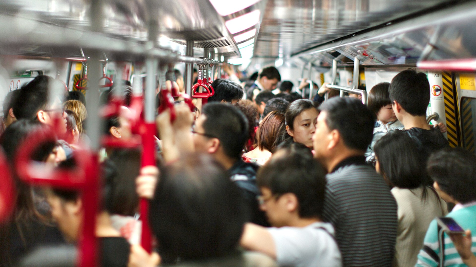 Vollbesetzter U‑Bahn‑Wagen im urbanen Schienenverkehr in China mit stehenden Fahrgästen