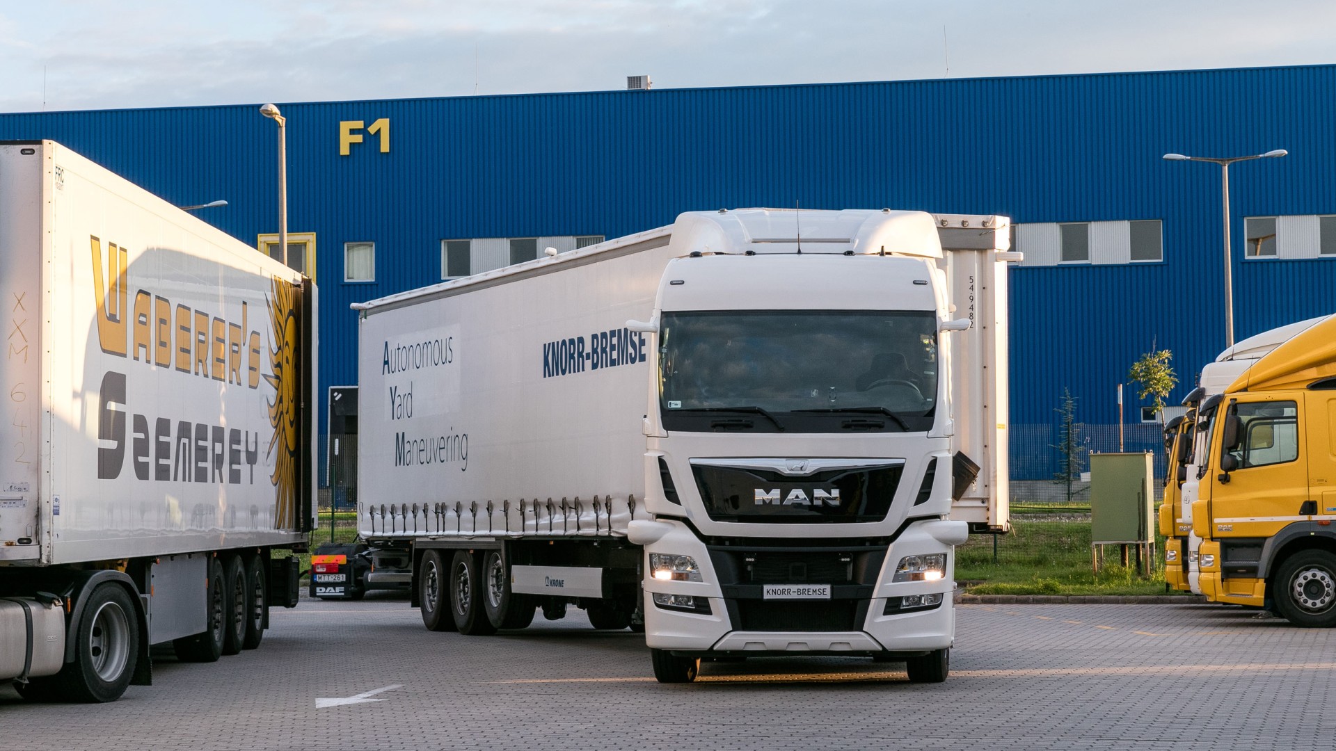 Autonom fahrender Sattelzug von Knorr‑Bremse mit leerem Fahrersitz beim Rangieren auf einem Speditionshof