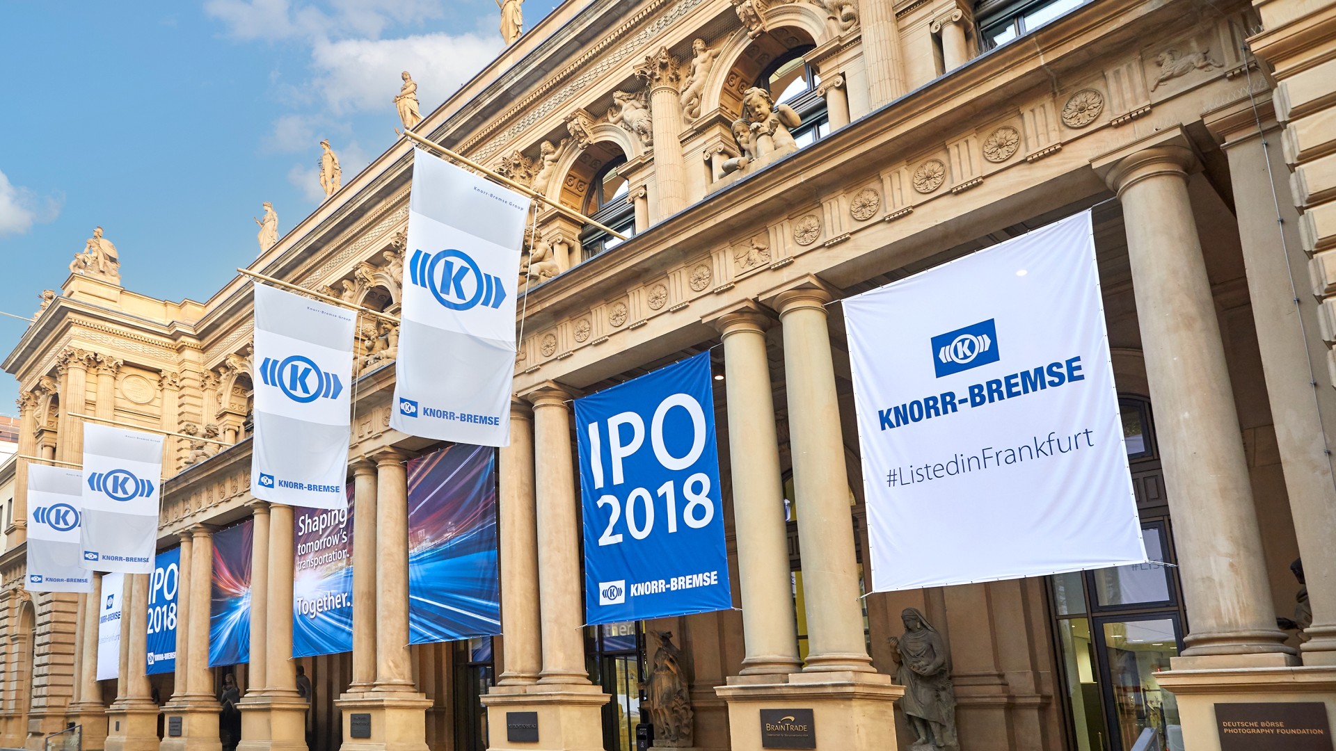 Knorr‑Bremse flags and IPO banners for the 2018 stock market listing in front of the Frankfurt Stock Exchange