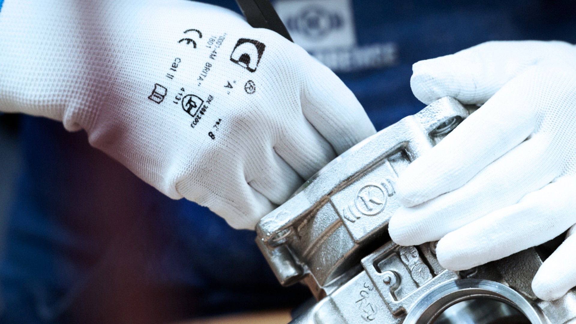 Manual work on a Knorr‑Bremse steel component using white industrial gloves as a symbol of precision, quality and excellence