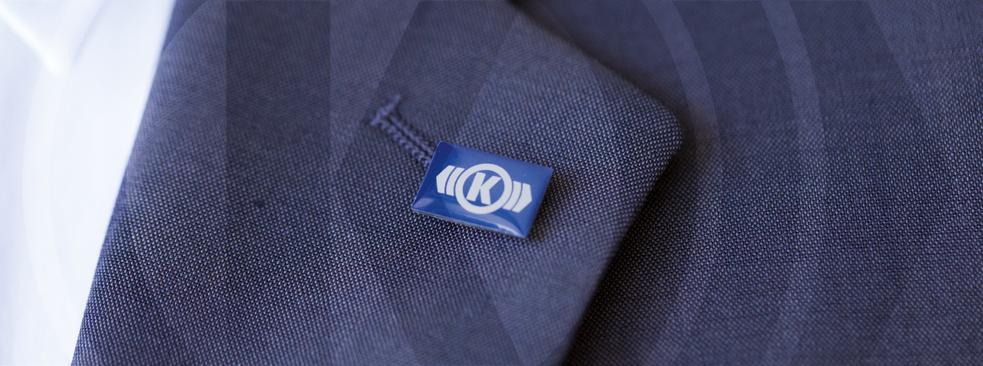 Knorr‑Bremse lapel pin with company logo on a suit jacket symbolizing corporate values and culture