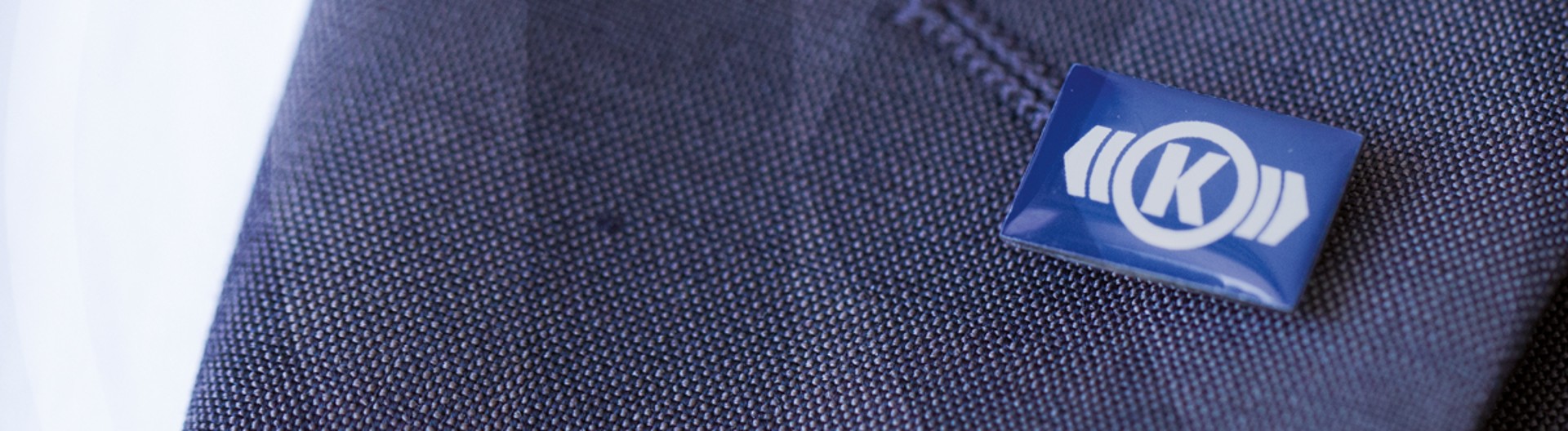 Knorr‑Bremse lapel pin with company logo on a suit jacket symbolizing corporate values and culture