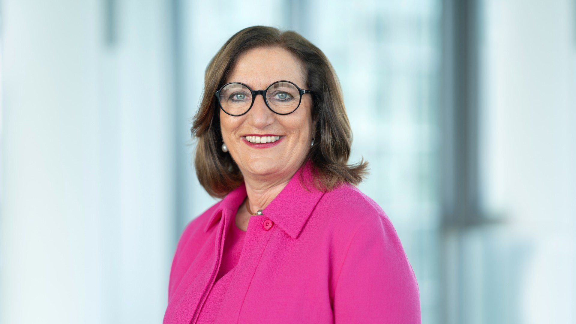Portrait photo of a Knorr‑Bremse AG executive responsible for Integrity, Legal, IP, Data Protection and HR, shown in a business outfit against a modern office background