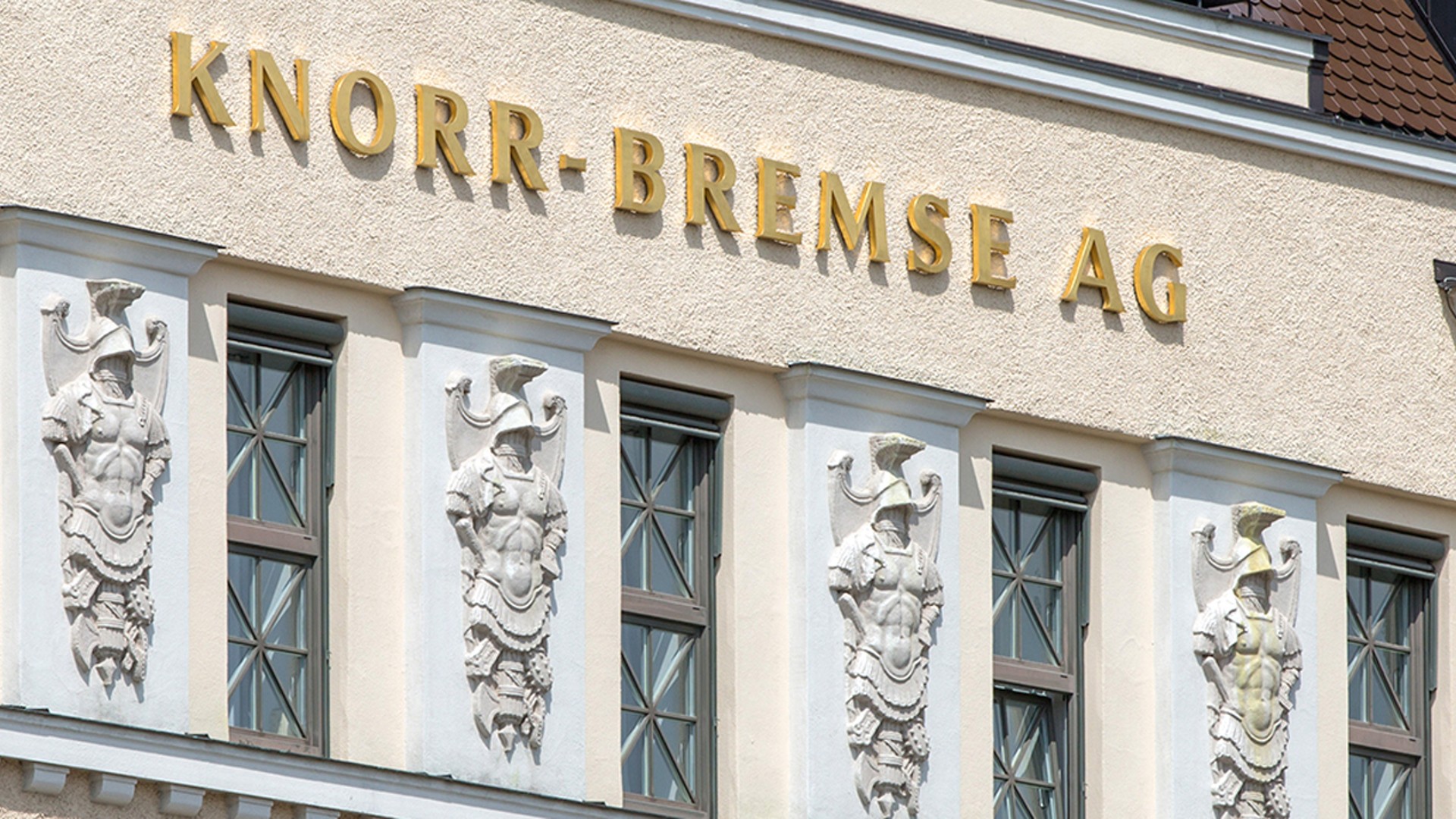 Exterior view of the historic Knorr‑Bremse AG company building in Munich featuring gold lettering and decorative facade ornaments