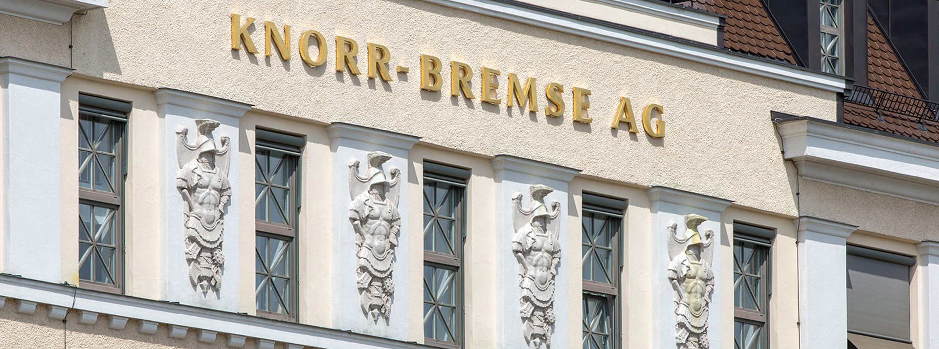Außenansicht des historischen Knorr‑Bremse AG Firmengebäudes in München mit goldener Schrift und Fassadenornamenten