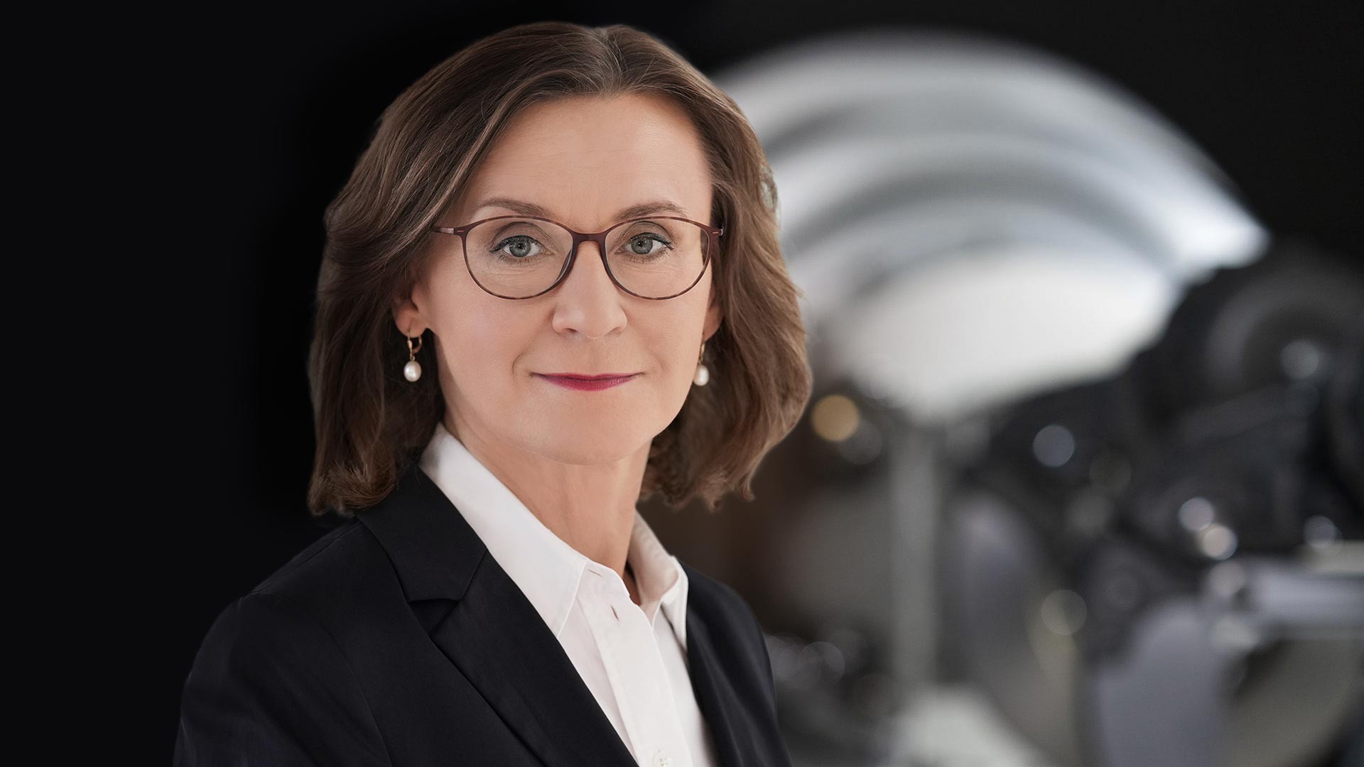 Business‑Portrait eines Aufsichtsratsmitglieds der Knorr‑Bremse AG vor industrieller Maschinenkomponente