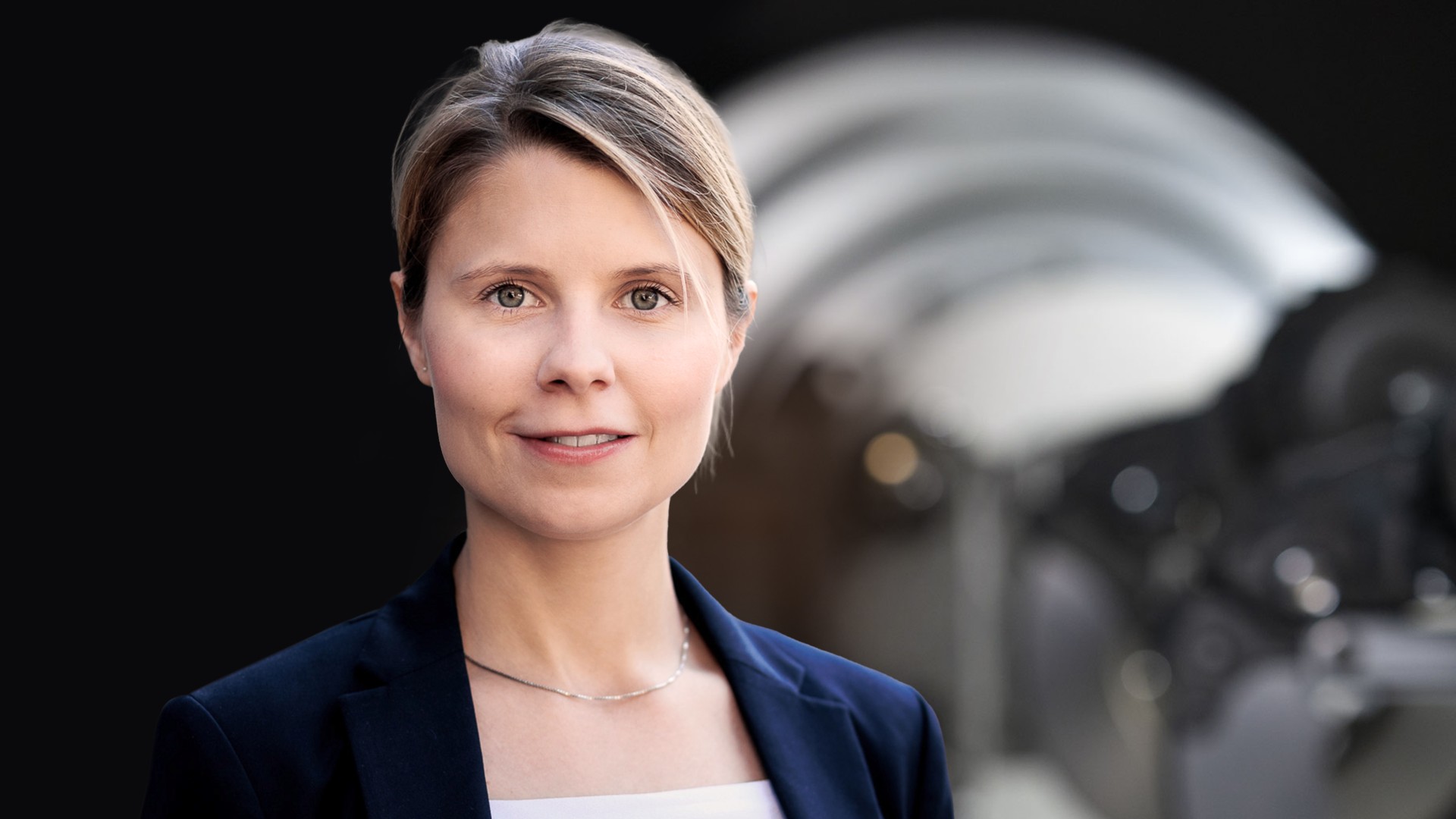 Business‑Portrait eines Aufsichtsratsmitglieds der Knorr‑Bremse AG vor industrieller Maschinenkomponente