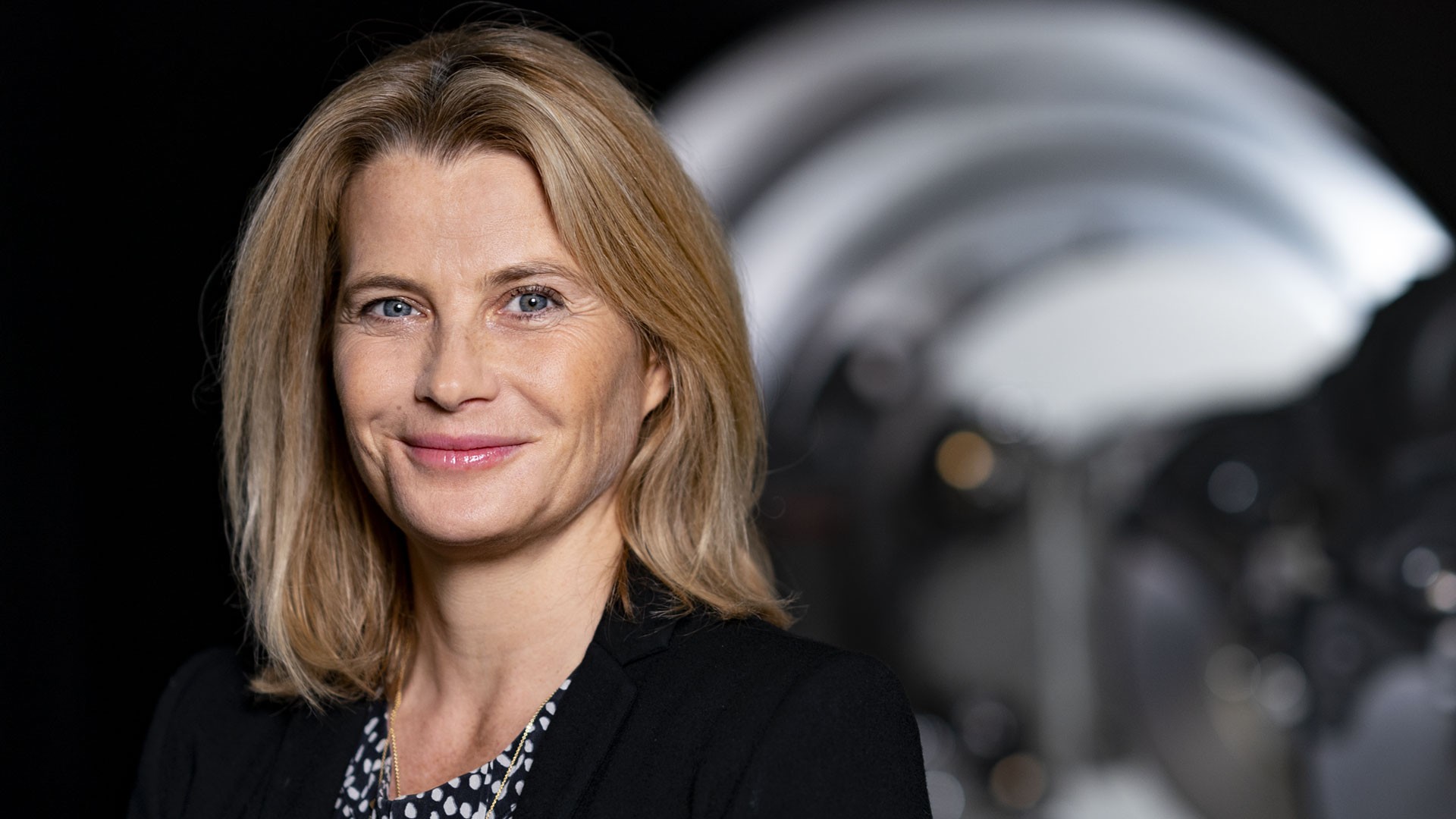 Business portrait of a supervisory board member of Knorr-Bremse AG in front of an industrial machinery component