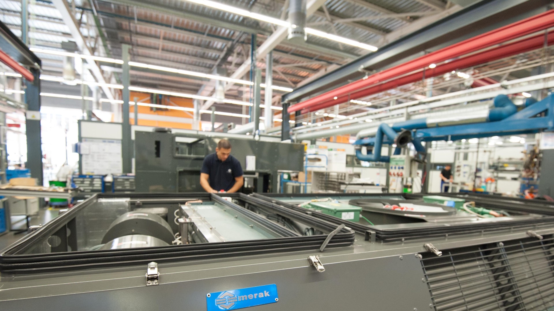 Ein Mitarbeiter von Merak arbeitet in der Produktionshalle an einem Klimasystem für Züge.