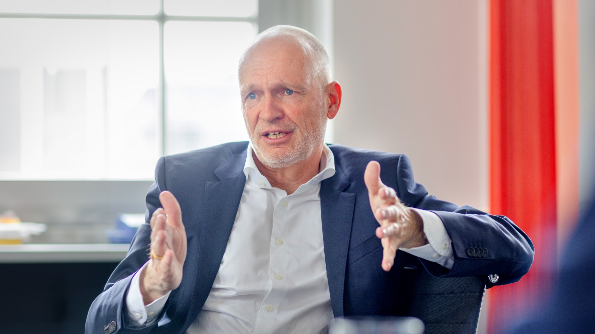 Dr. Nicolas Lange, Vorstandsmitglied der Knorr-Bremse AG und verantwortlich für die Division Systeme für Schienenfahrzeuge, sitzt in seinem Büro am Besprechungstisch und antwortet auf die Interviewfragen seiner Gesprächspartnerin.