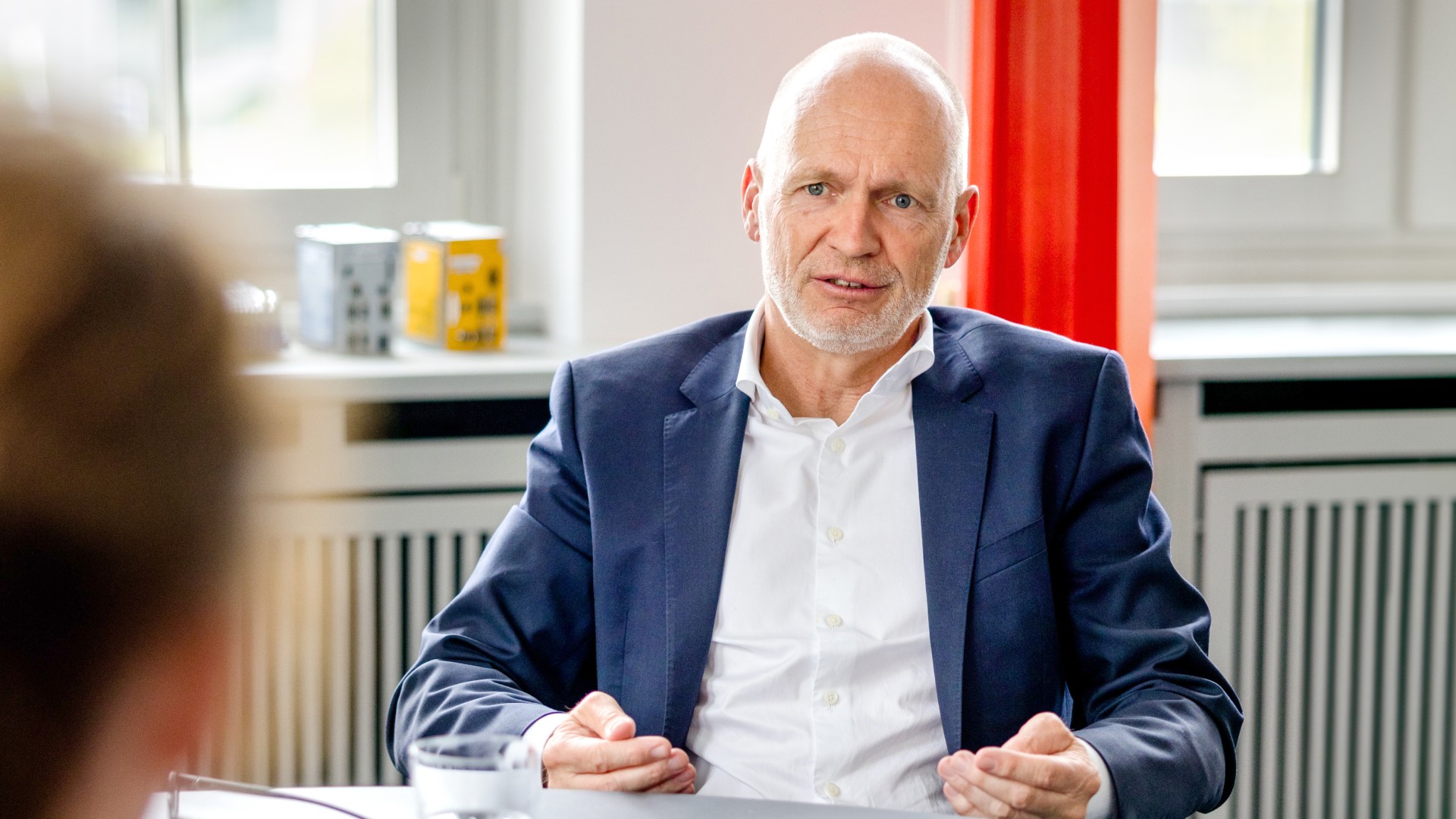 Dr. Nicolas Lange, Vorstandsmitglied der Knorr-Bremse AG und verantwortlich für die Division Systeme für Schienenfahrzeuge, sitzt in seinem Büro am Besprechungstisch und antwortet auf die Interviewfragen seiner Gesprächspartnerin.