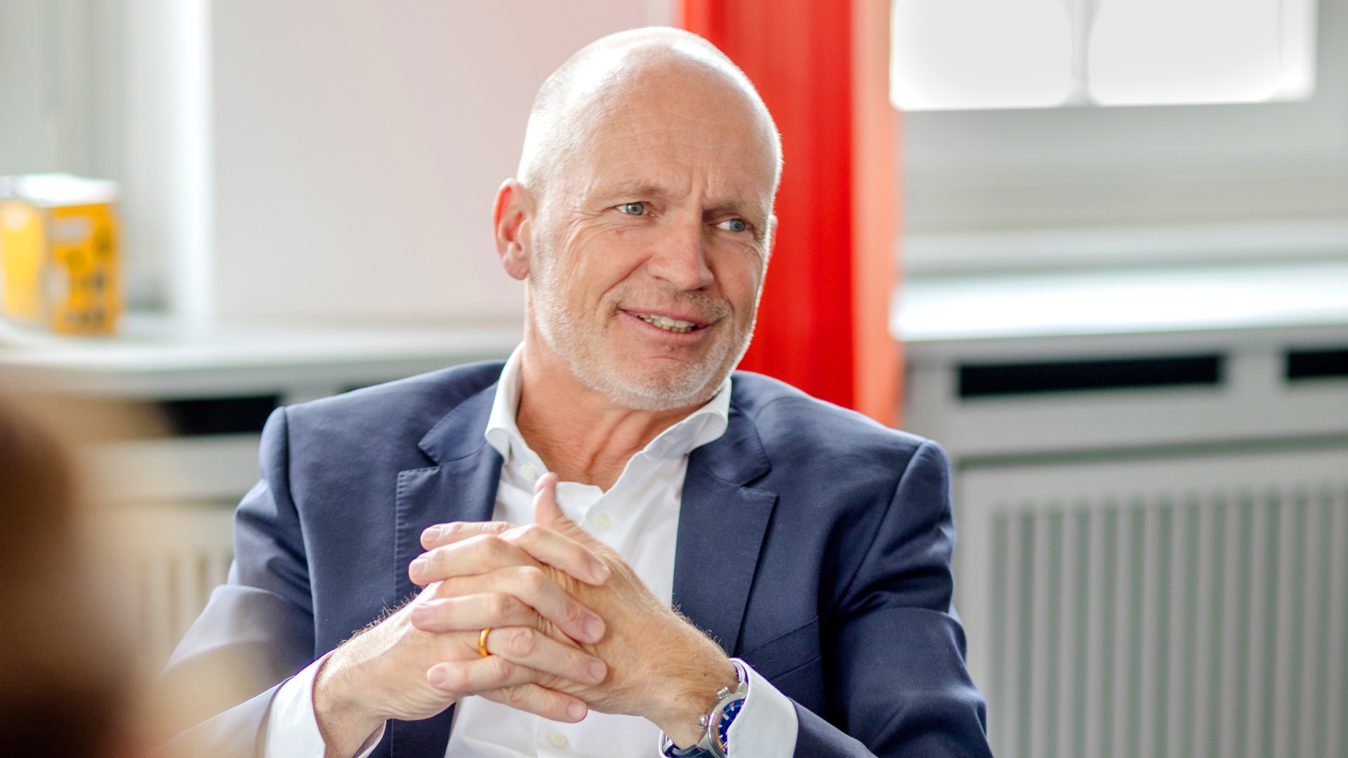Dr. Nicolas Lange, Vorstandsmitglied der Knorr-Bremse AG und verantwortlich für die Division Systeme für Schienenfahrzeuge, sitzt in seinem Büro am Besprechungstisch und antwortet auf die Interviewfragen seiner Gesprächspartnerin.