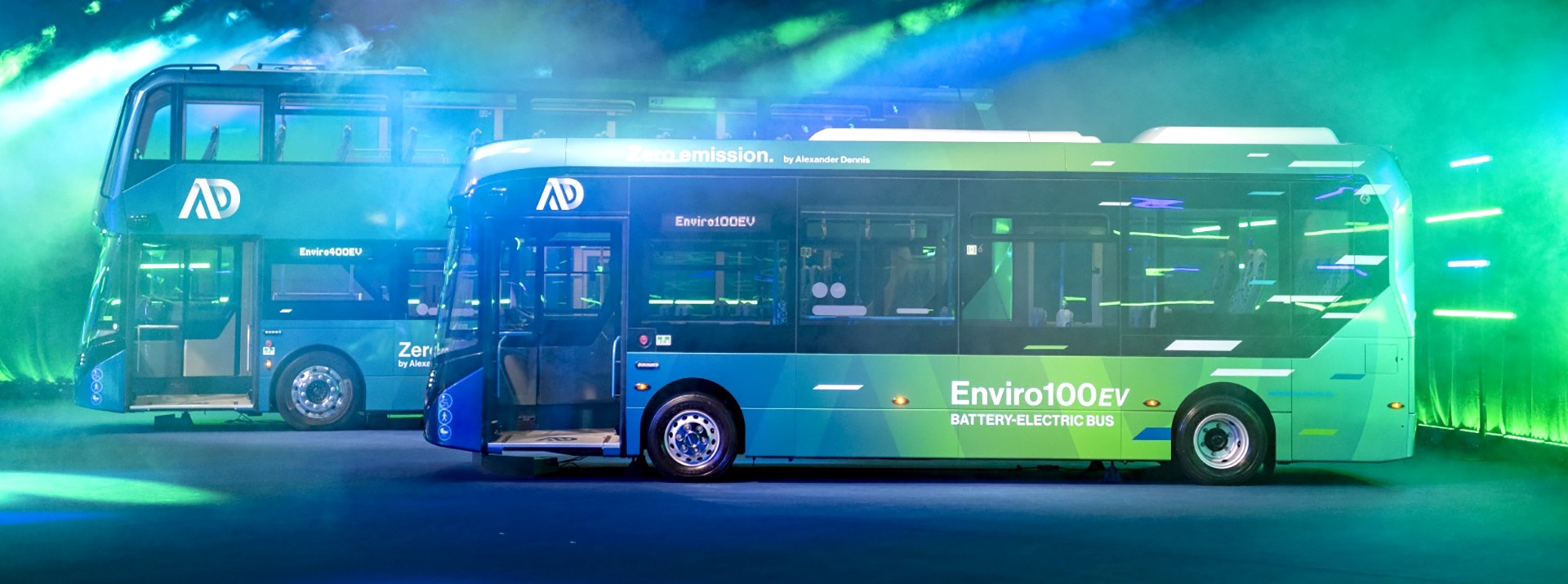 Bereit für den Launch: Die beiden neuen Busmodelle Enviro 400EV und Enviro 100 EV stehen bunt beleuchtet im Showroom.
