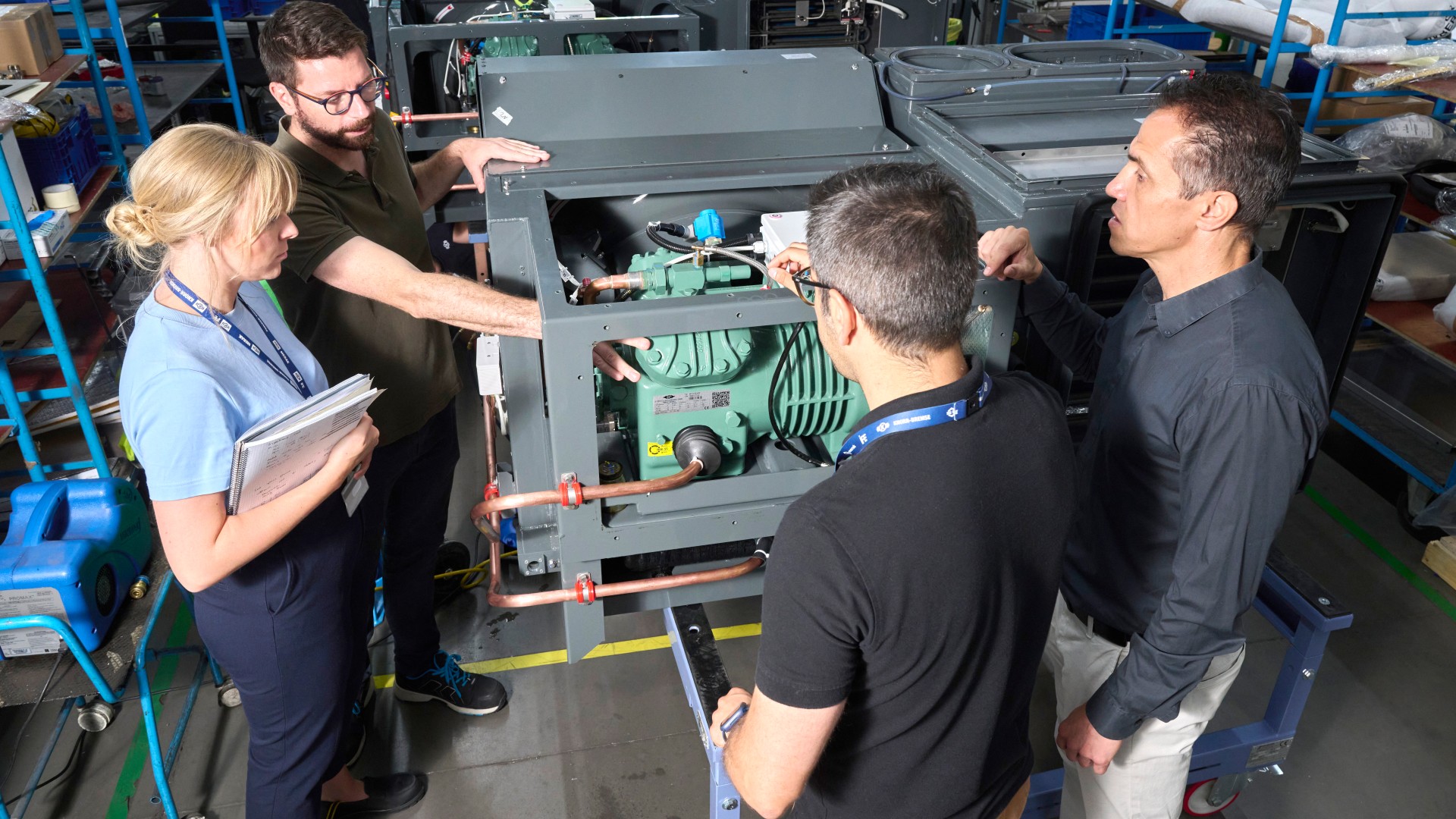Project team inspecting an air conditioning unit in the production hall of the Knorr‑Bremse plant in Getafe, Spain