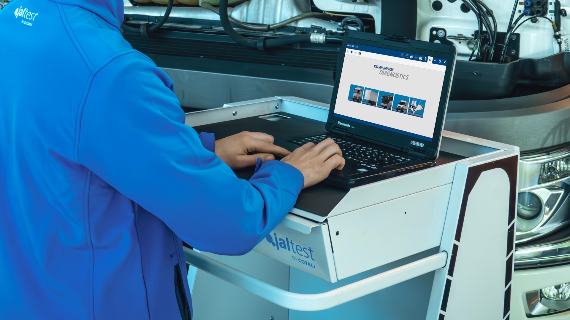 Digital vehicle diagnostics on a truck using laptop‑based aftermarket software in a workshop