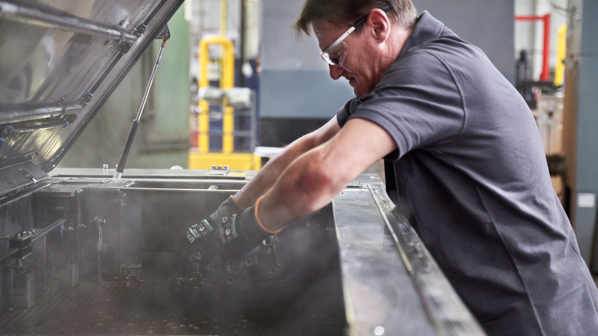 Manual cleaning and reconditioning of a commercial vehicle component in an industrial washing system at the Knorr‑Bremse remanufacturing plant in Liberec