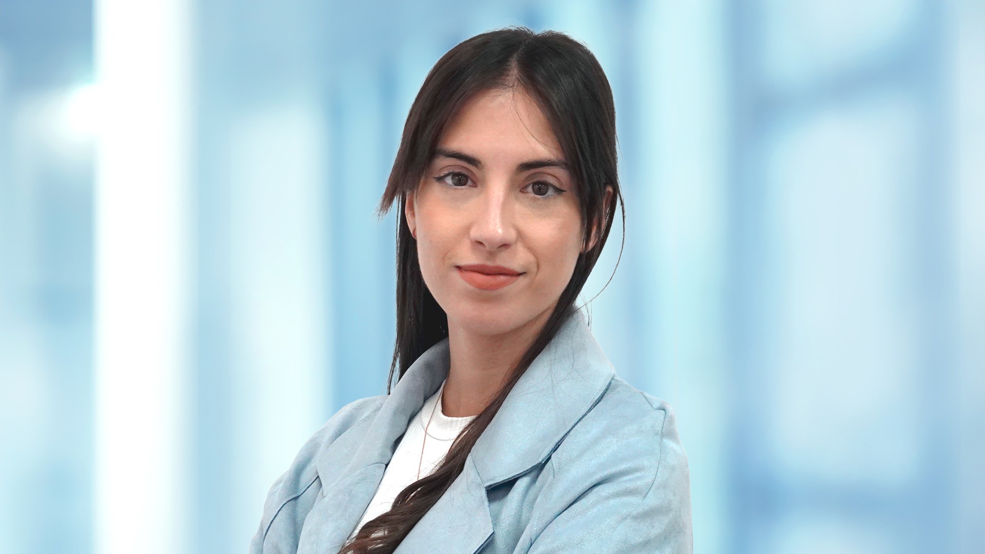 Employee portrait in business attire in front of a modern office background