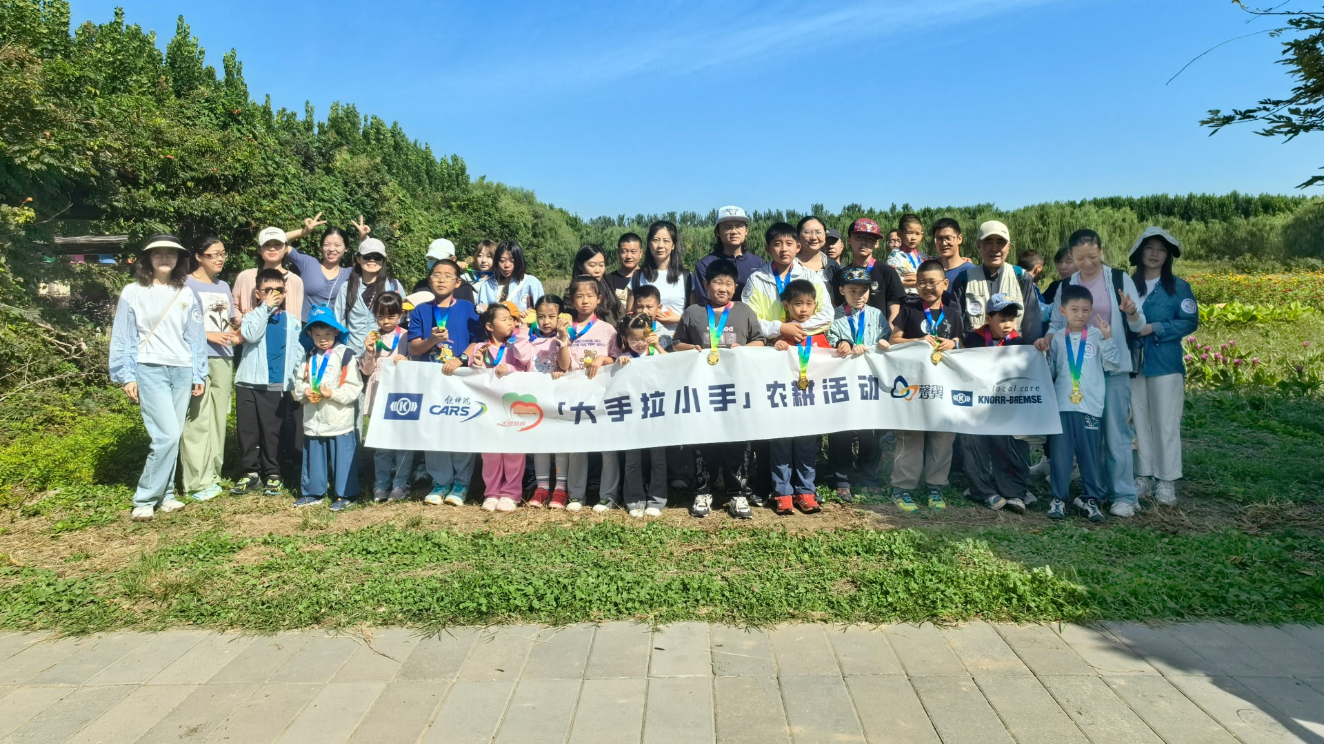 Group photo of employees from Daxing and families with autistic children during an outing to an adventure farm
