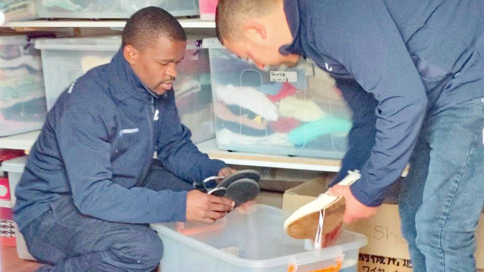 Employees sort donated shoes and clothing for children at an orphanage