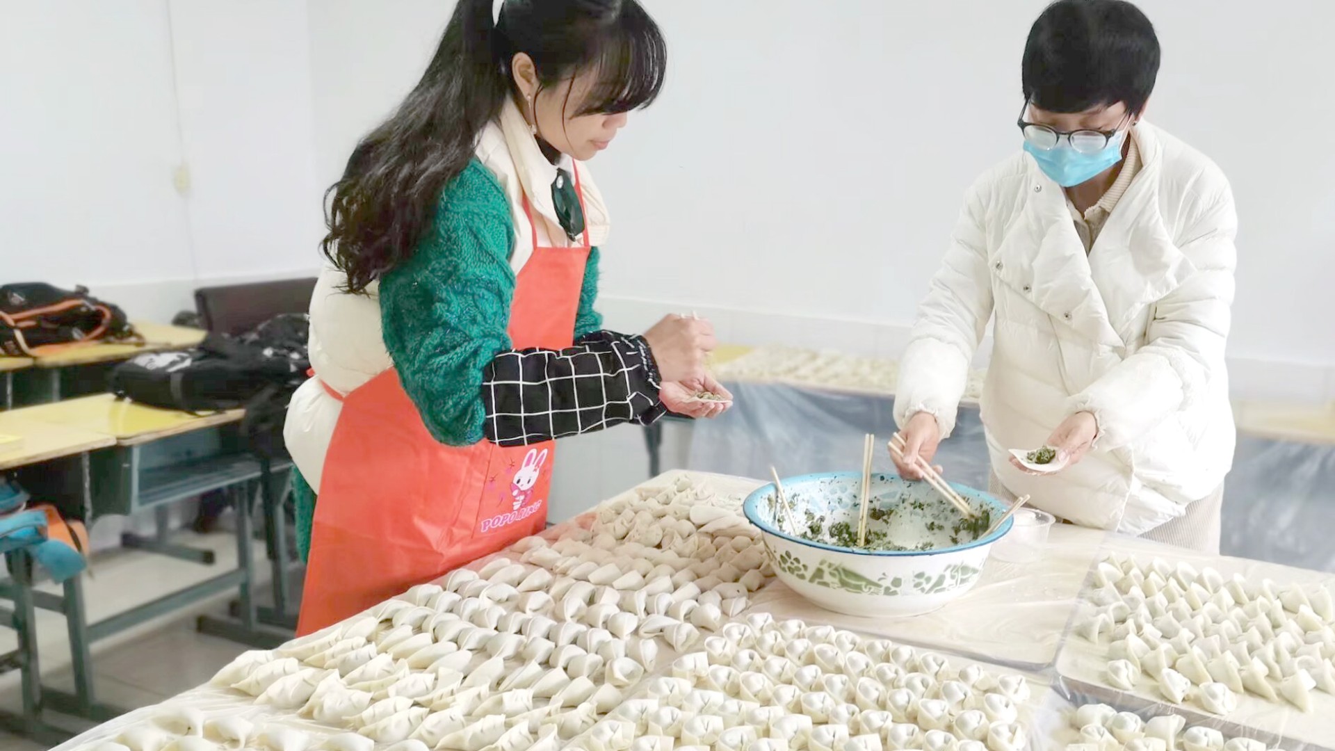 Female employees from Shiyan prepare Chinese dumplings together for the children of migrant workers