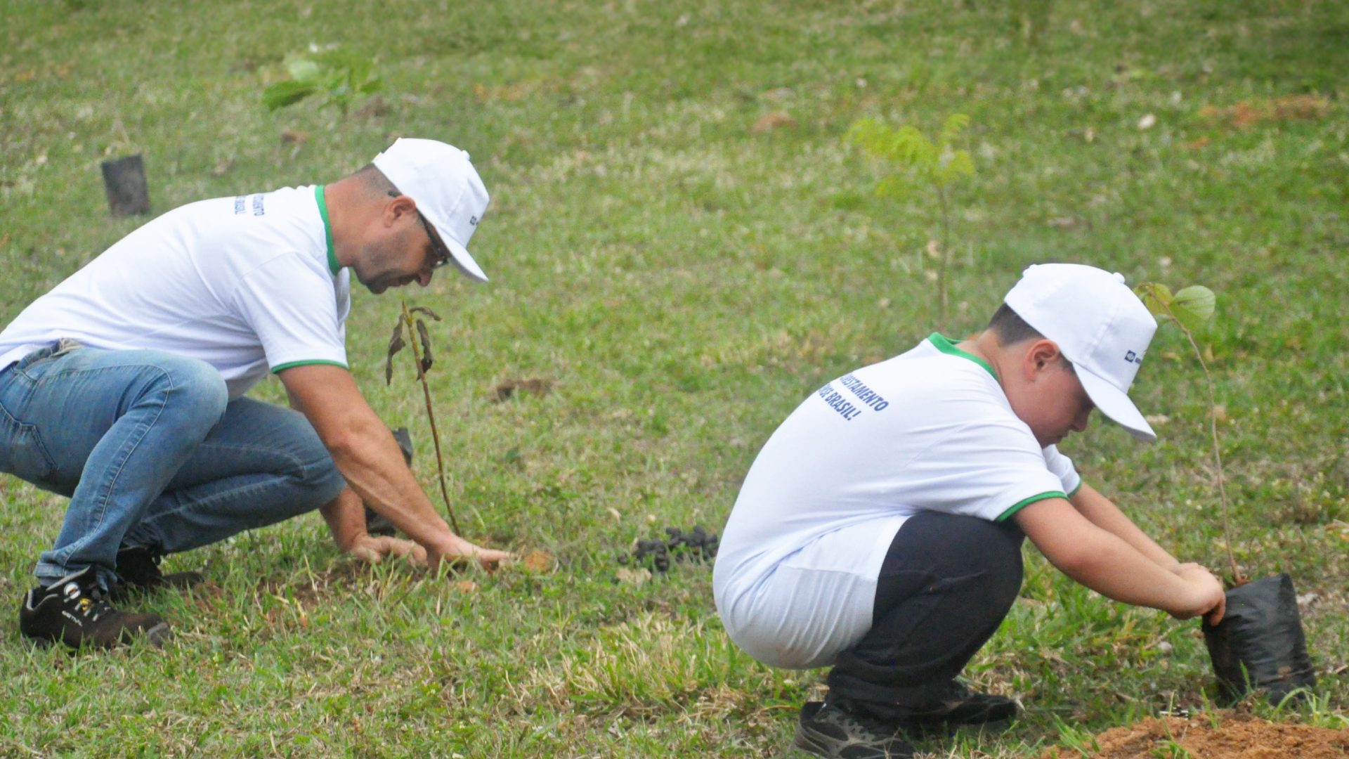 A Knorr‑Bremse employee plants young trees together with a child as part of an environmental initiative