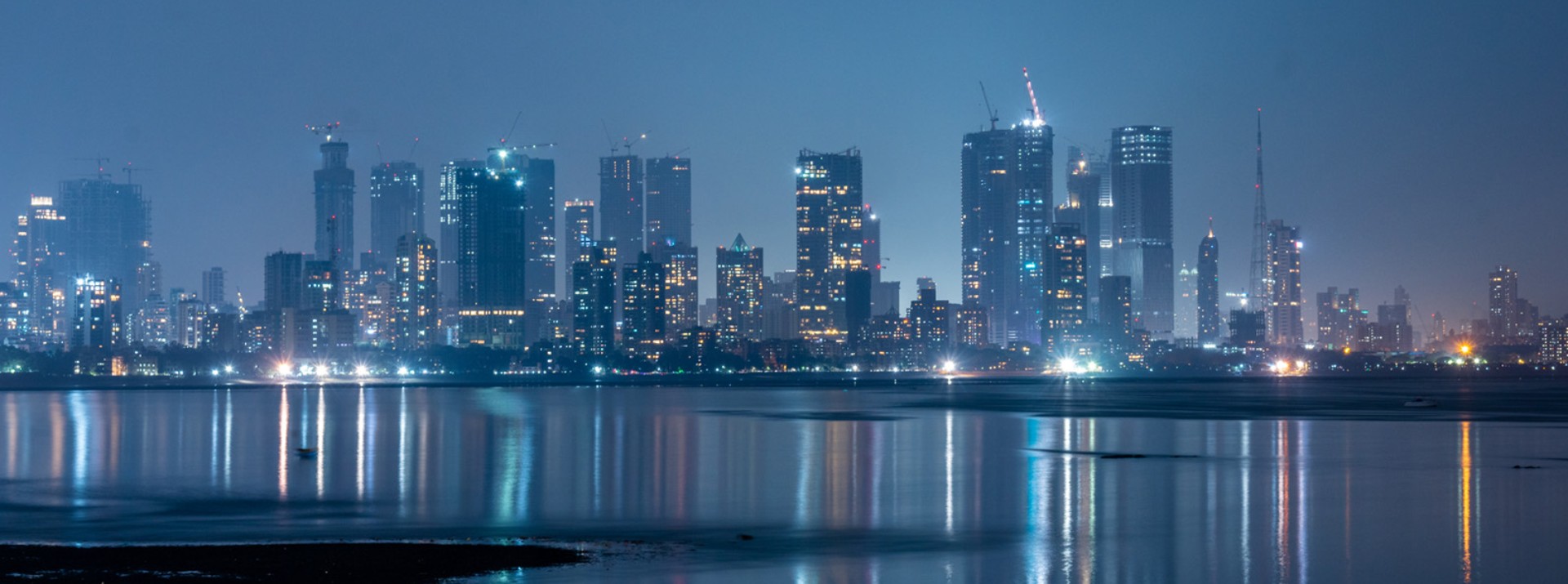 Nighttime skyline of Mumbai with illuminated high‑rise buildings – symbolic image of the vibrant urban dynamism of the Indian metropolis