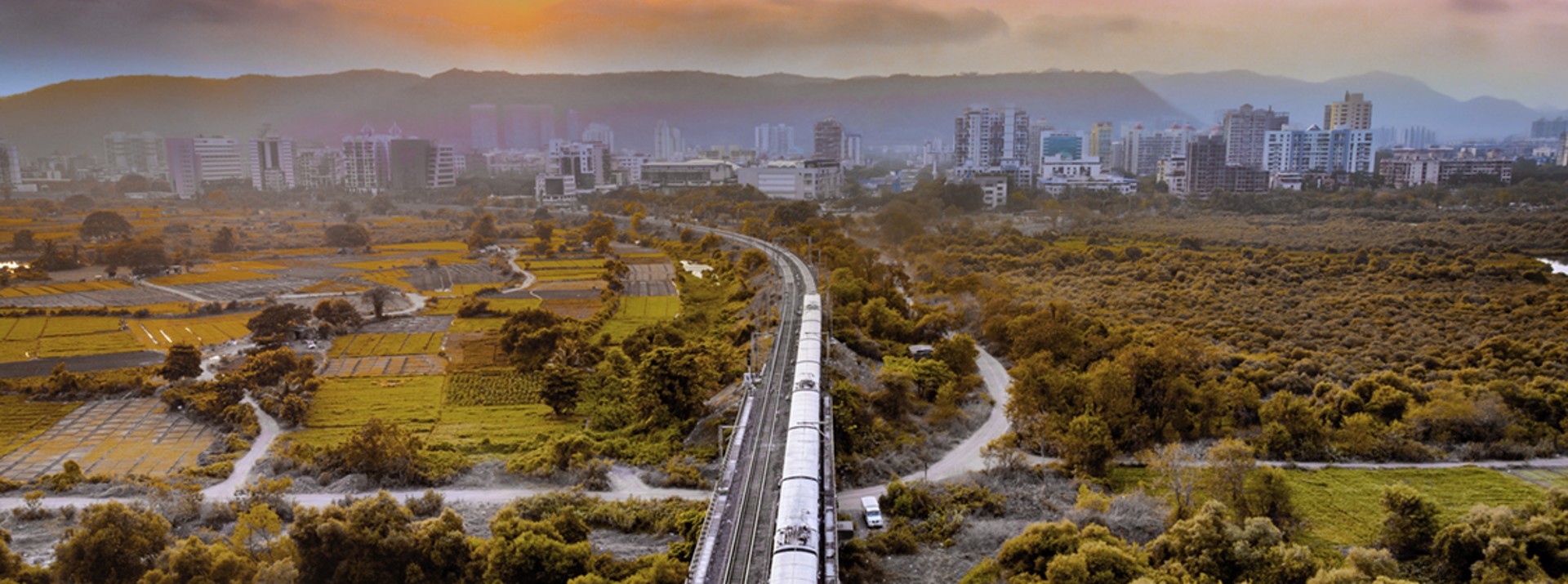 Train traveling through the mangrove landscape near Mumbai – symbolic image highlighting the importance of rail transport for the region’s urban mobility
