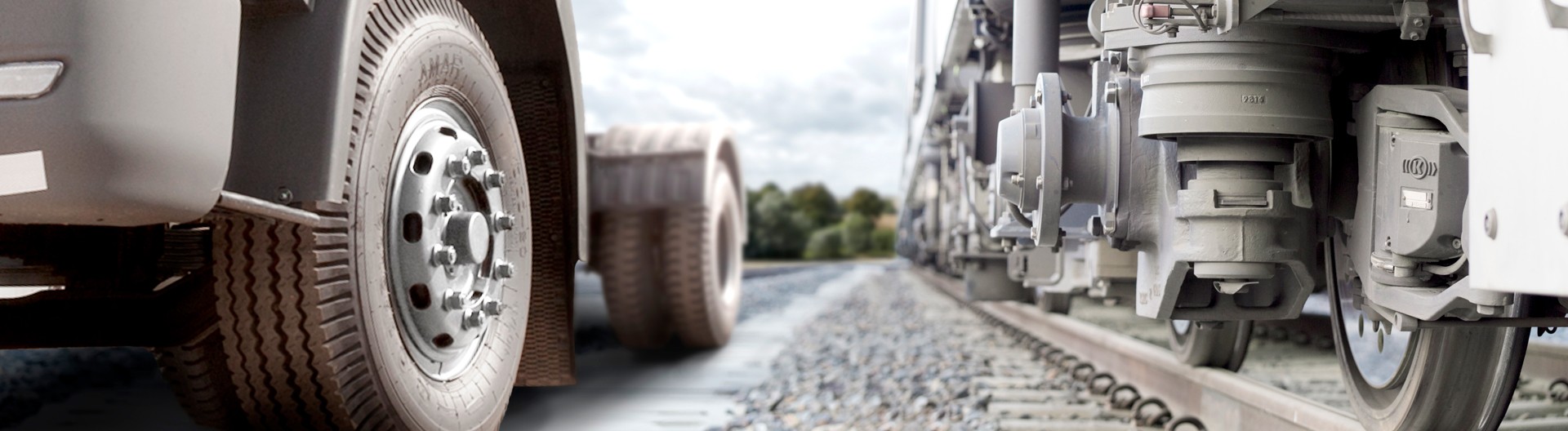Close-up comparison of a truck wheel and a train bogie on road and rail